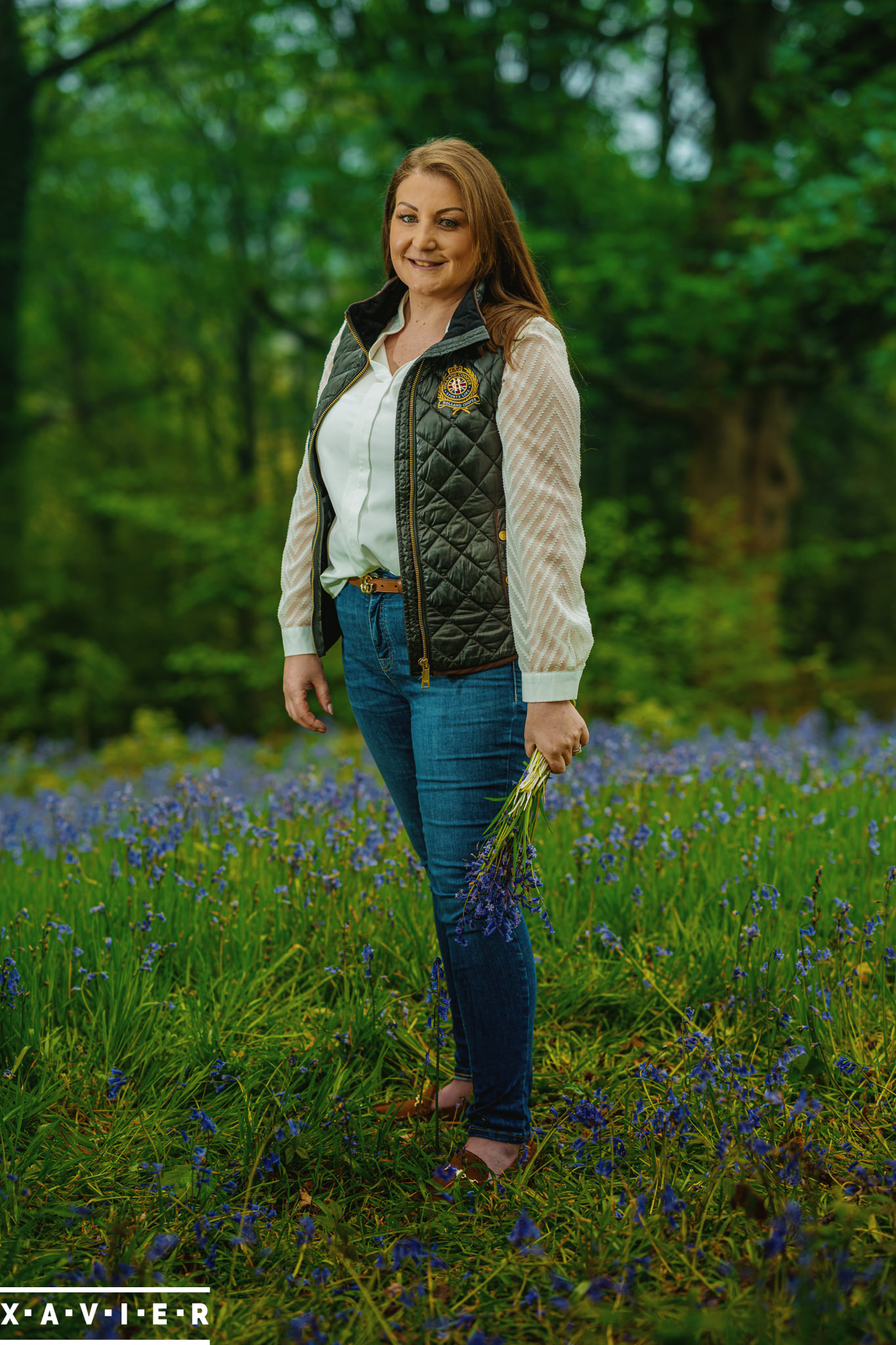 bride-to-be standing in bluebell wood during engagement photography connection session