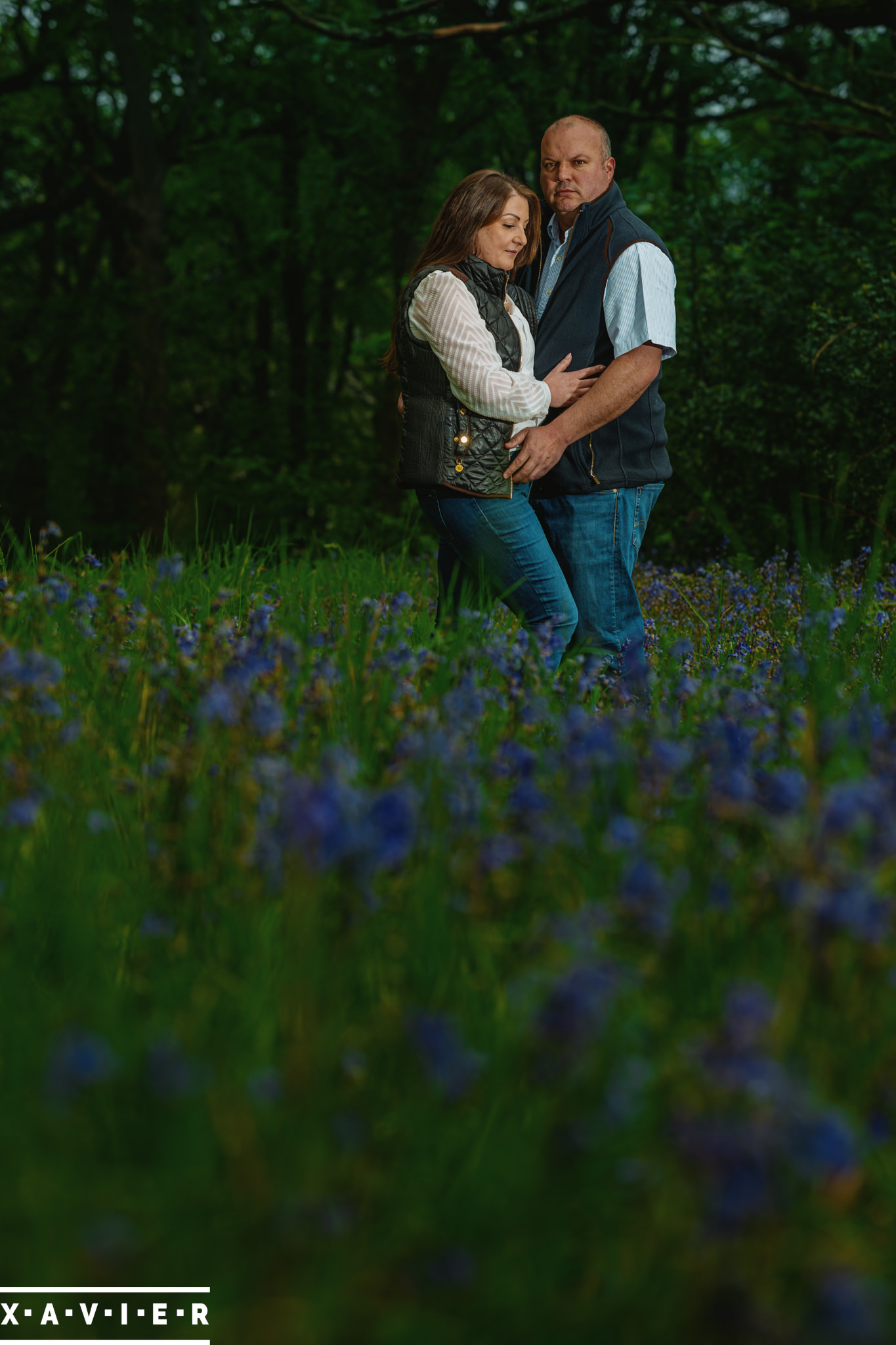 engagement photography couple standing in bluebell wood