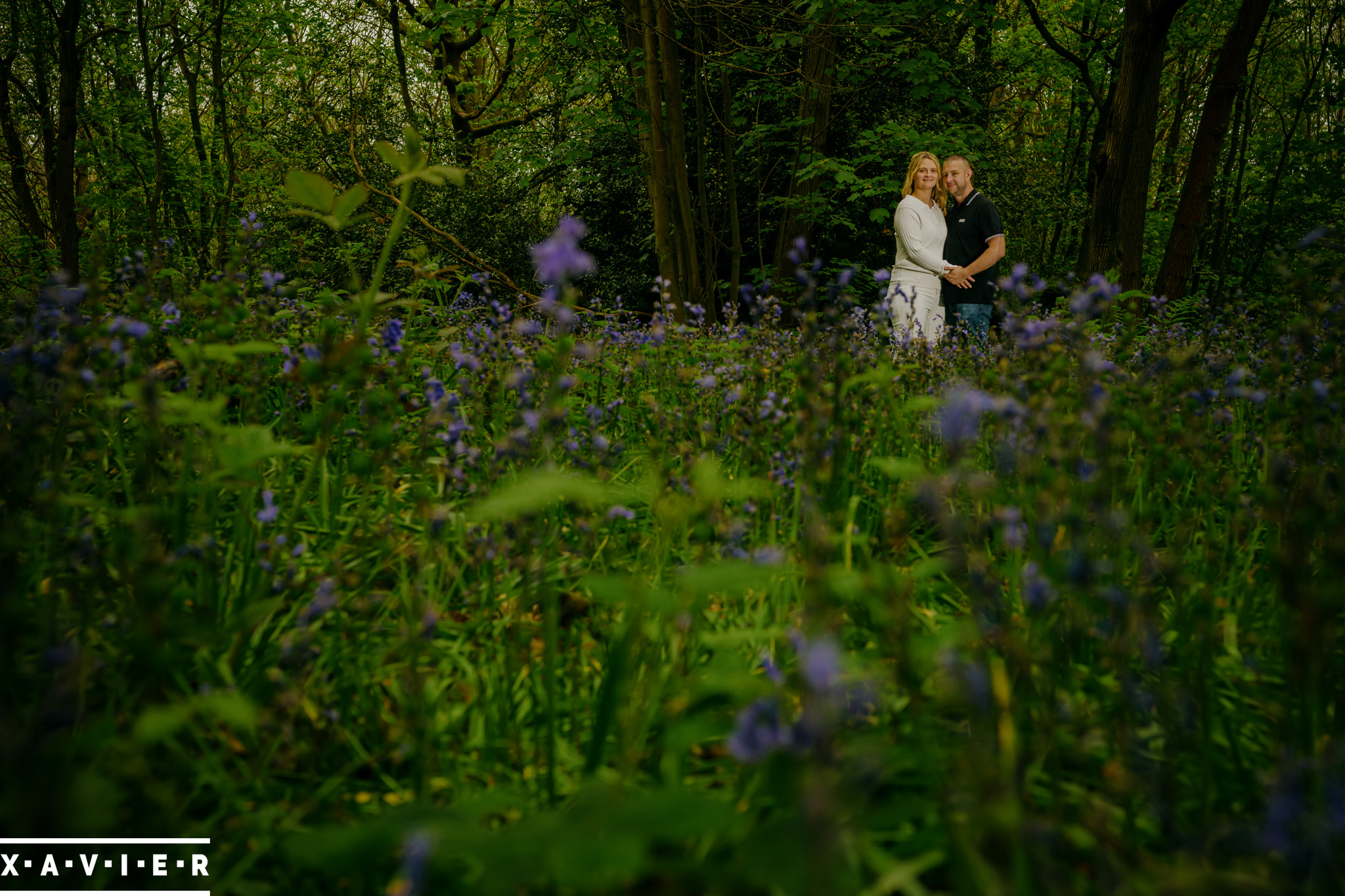 enagement couple in bluebell wood