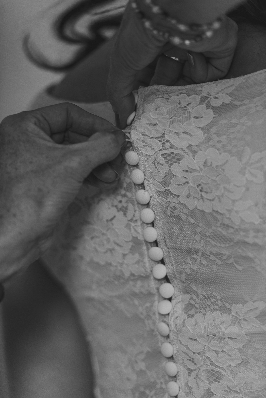 close up of the buttons on the brides wedding dress 