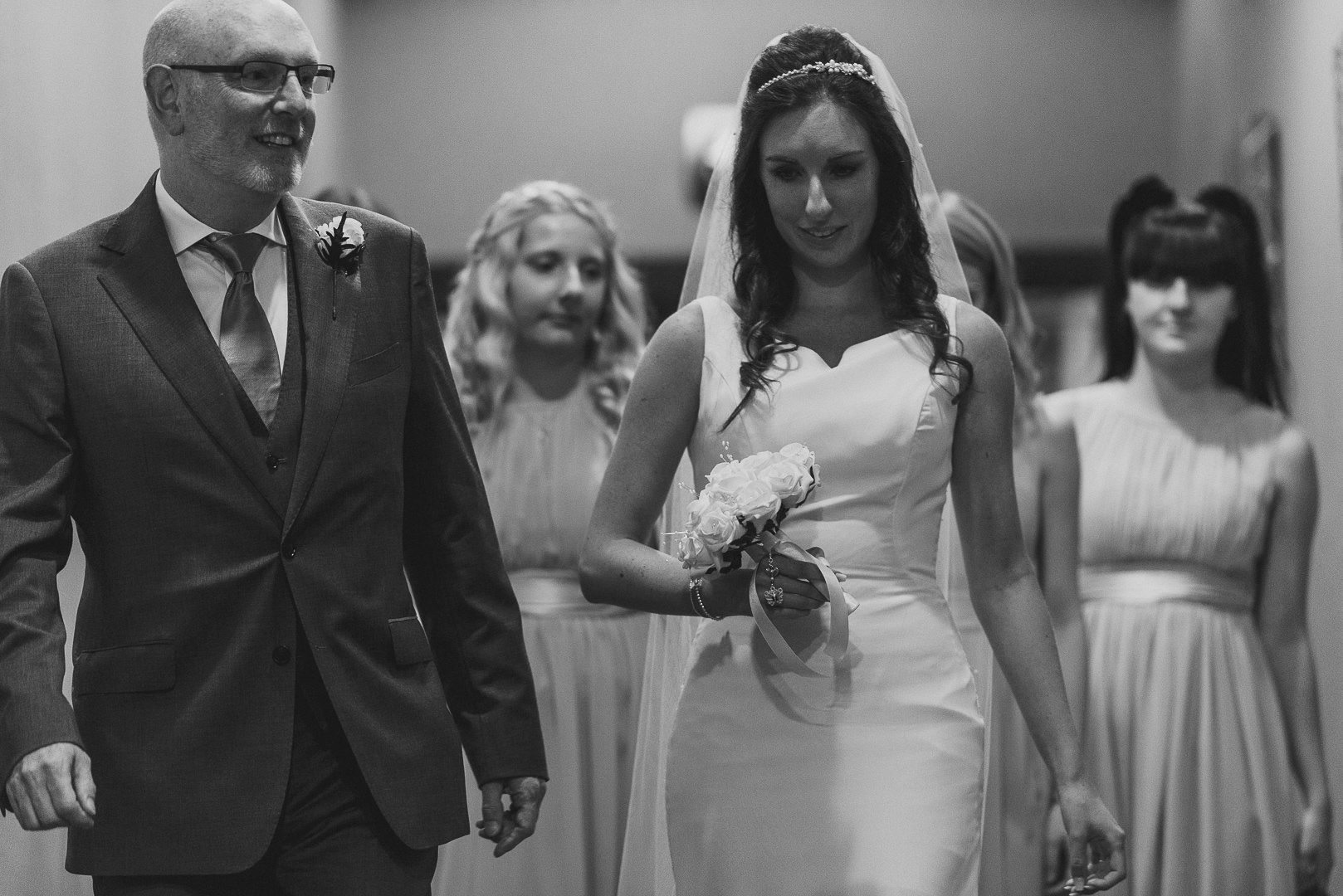The bride is walking with her father to the ceremony