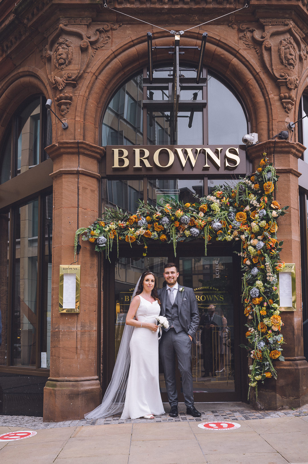The bride and groom are standing in front of browns restaruant