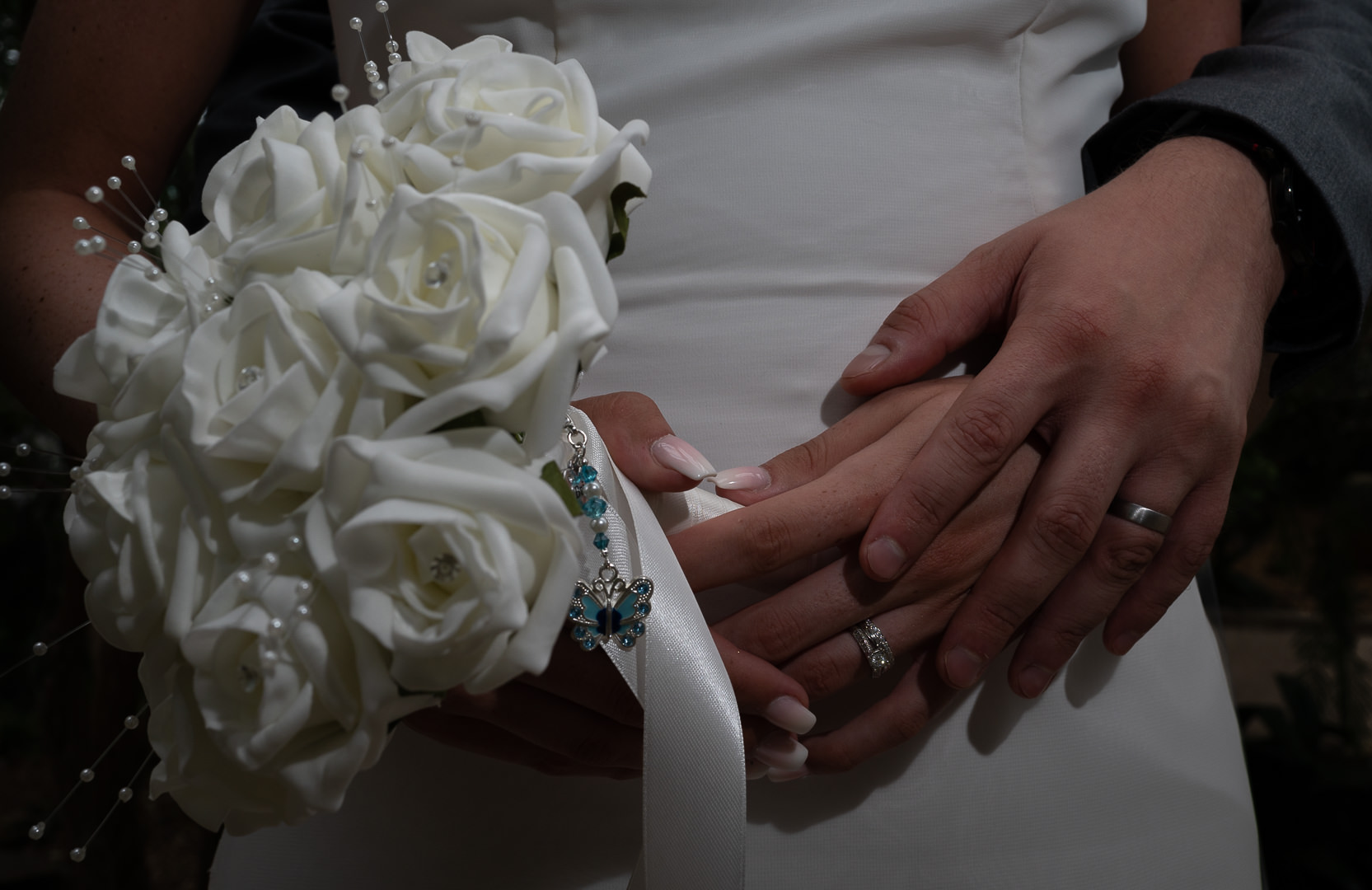Close up photo of the bride and groom's hands showing their rings
