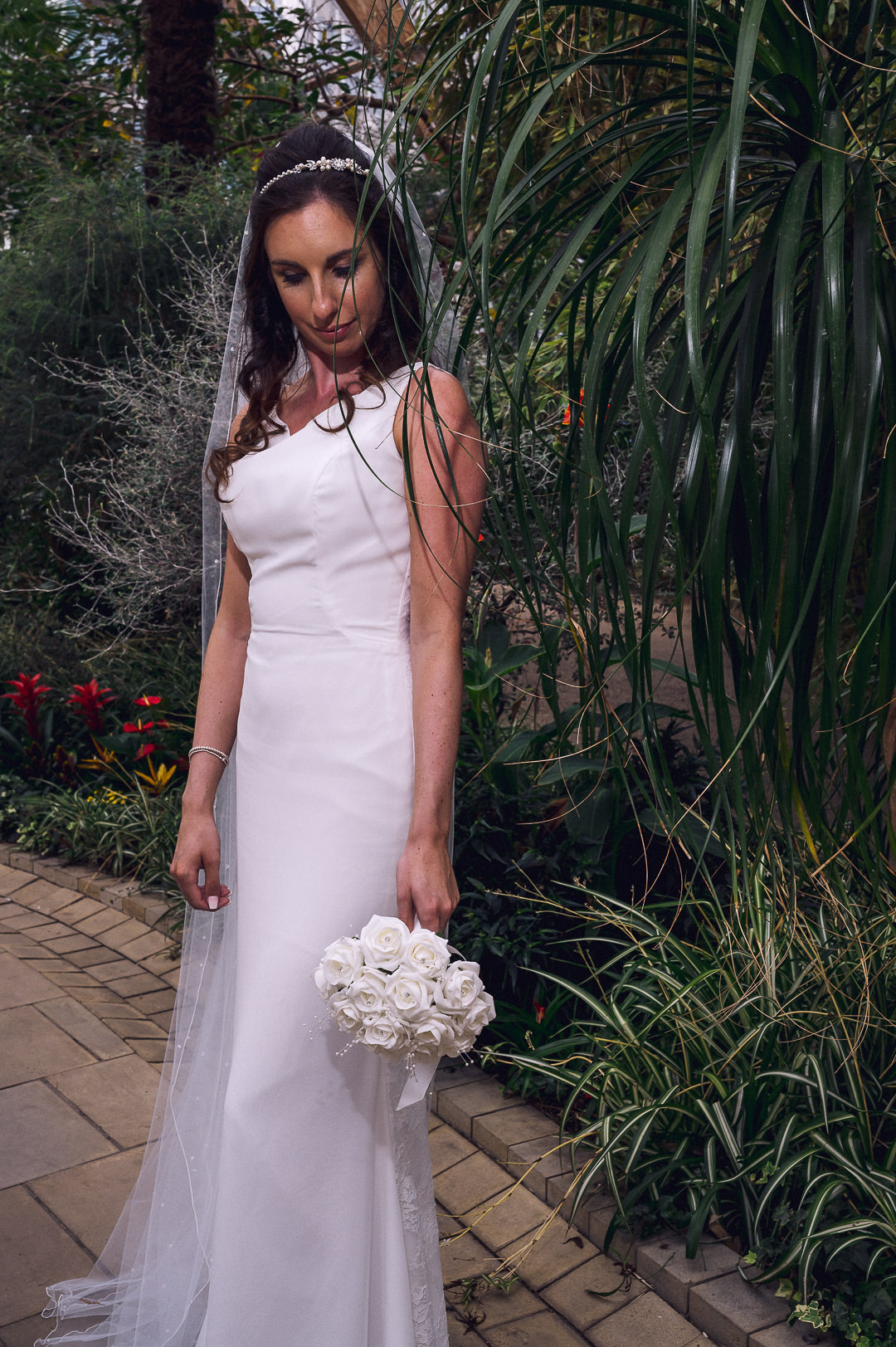 the bride poses alone in the winter gardens