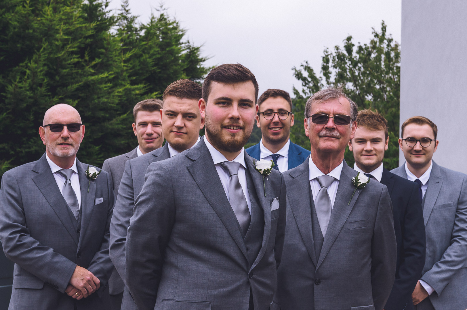 the groom stands in front of his groomsmen
