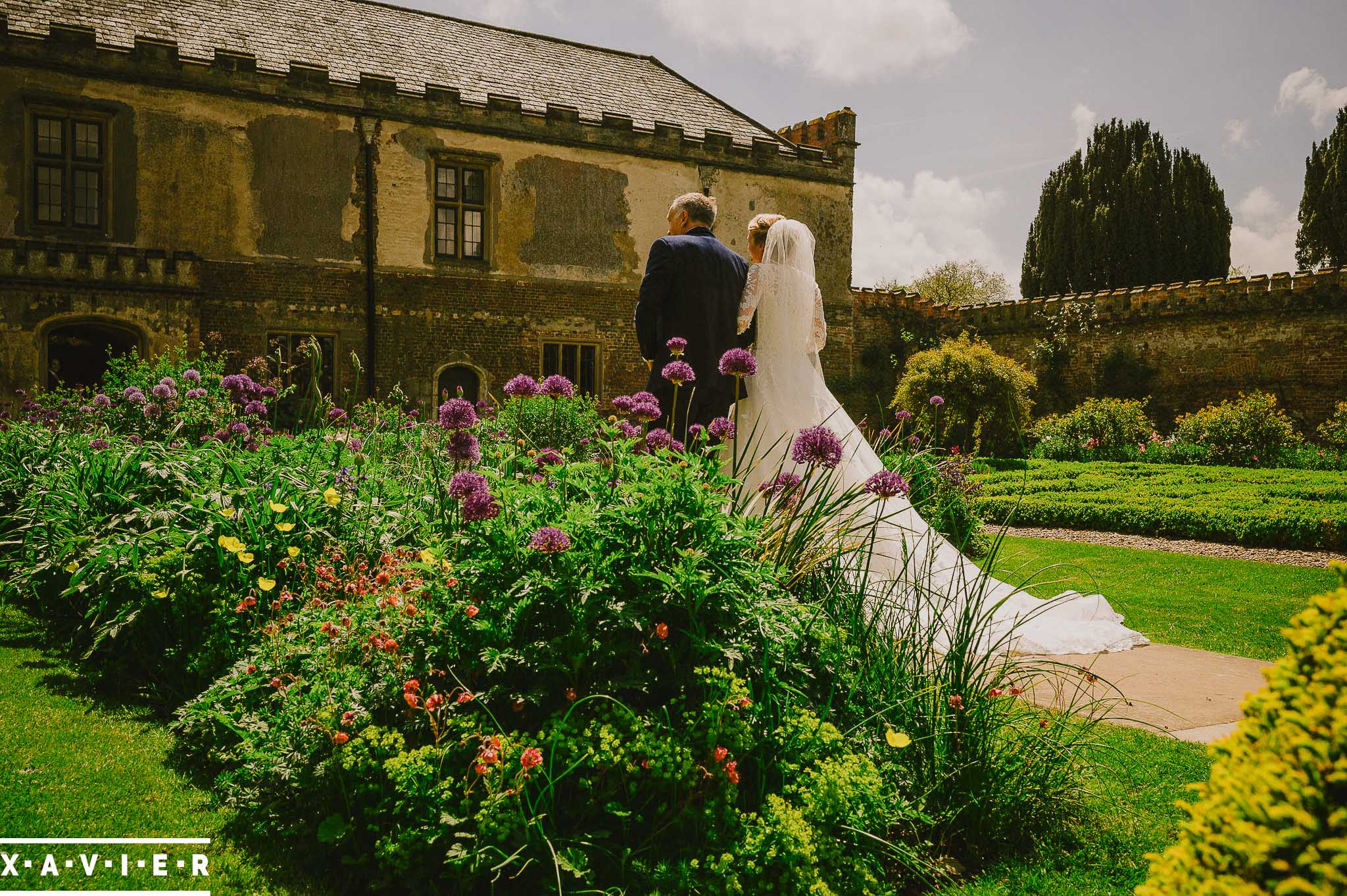 bride and father walk through the courtyard