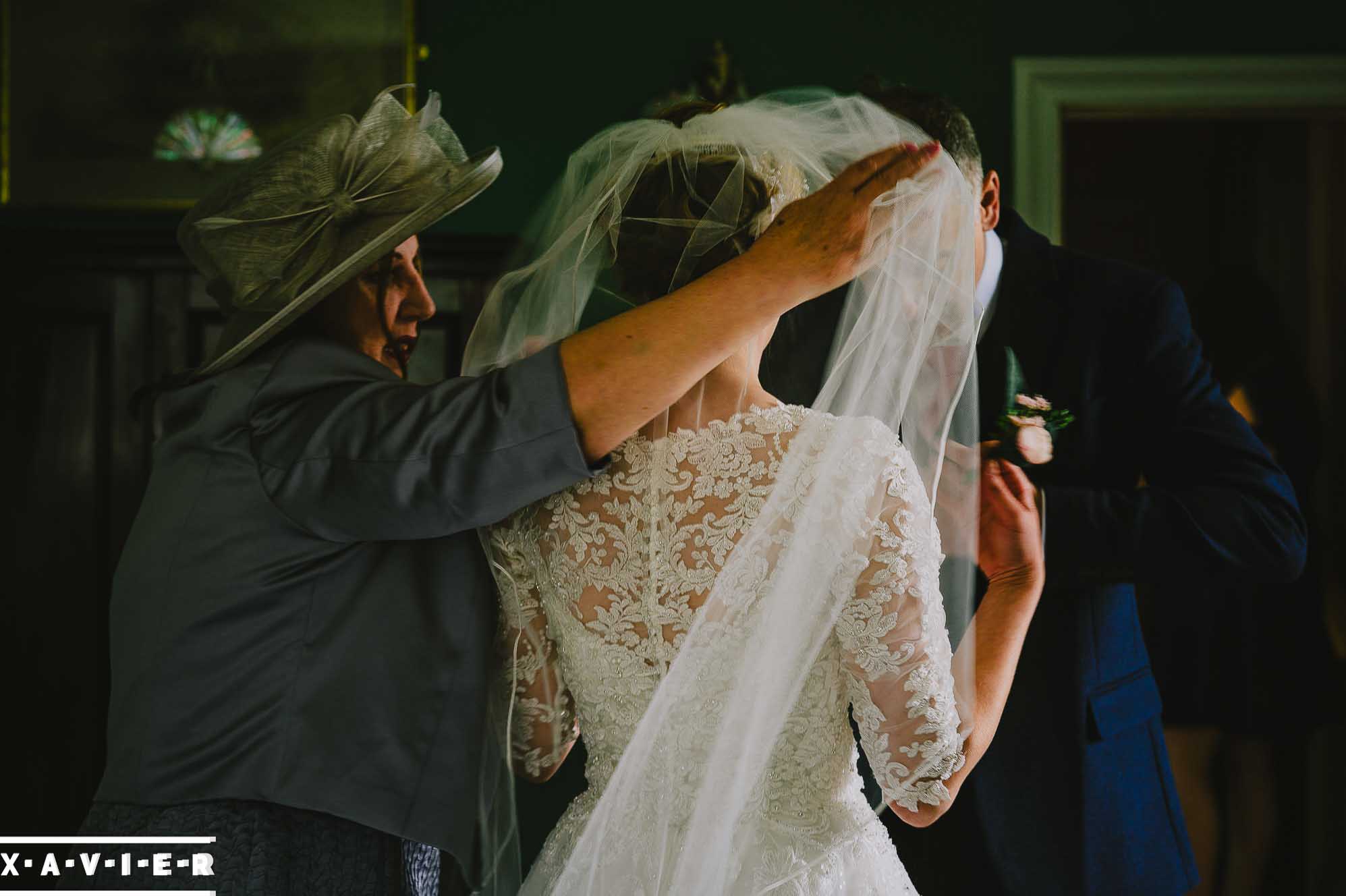 mother of the bride puts on the brides veil