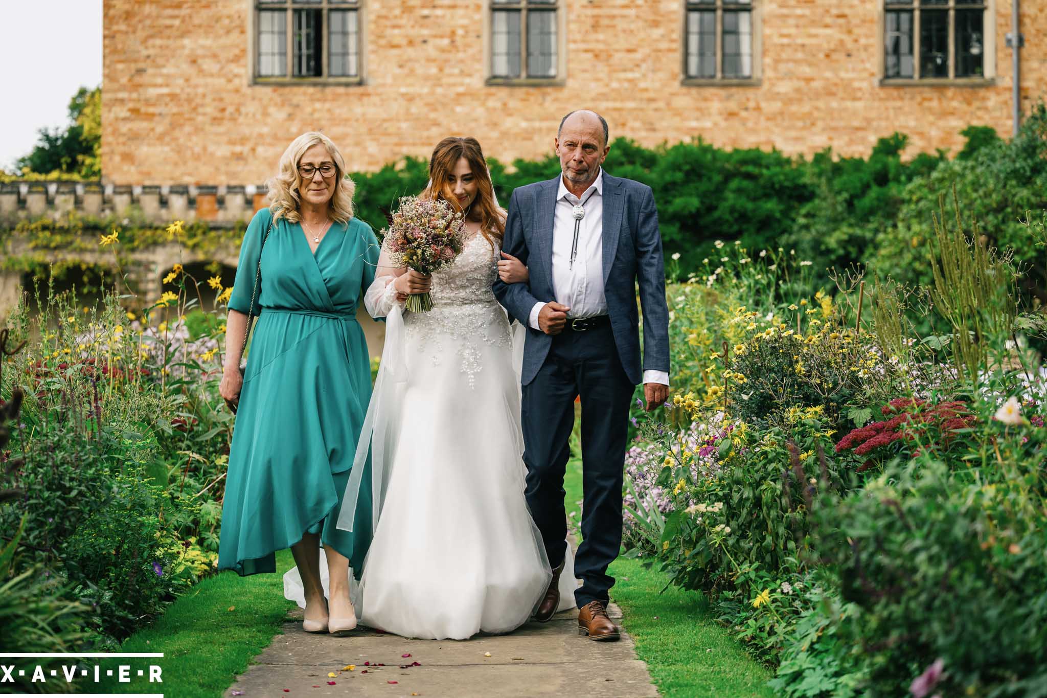 petals are scattered in fornt of the bride