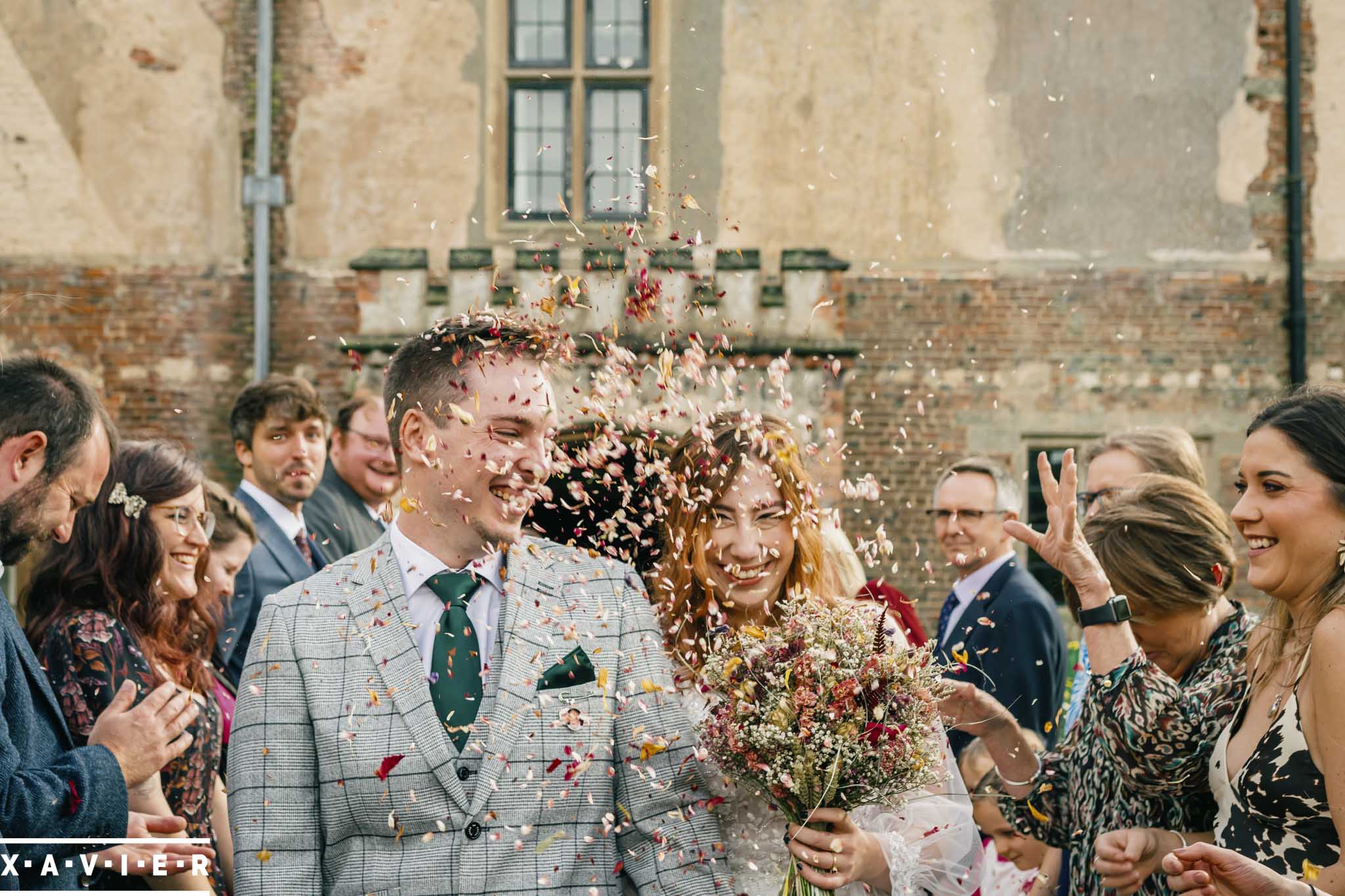 bride and groom walk through the confetti tunnel