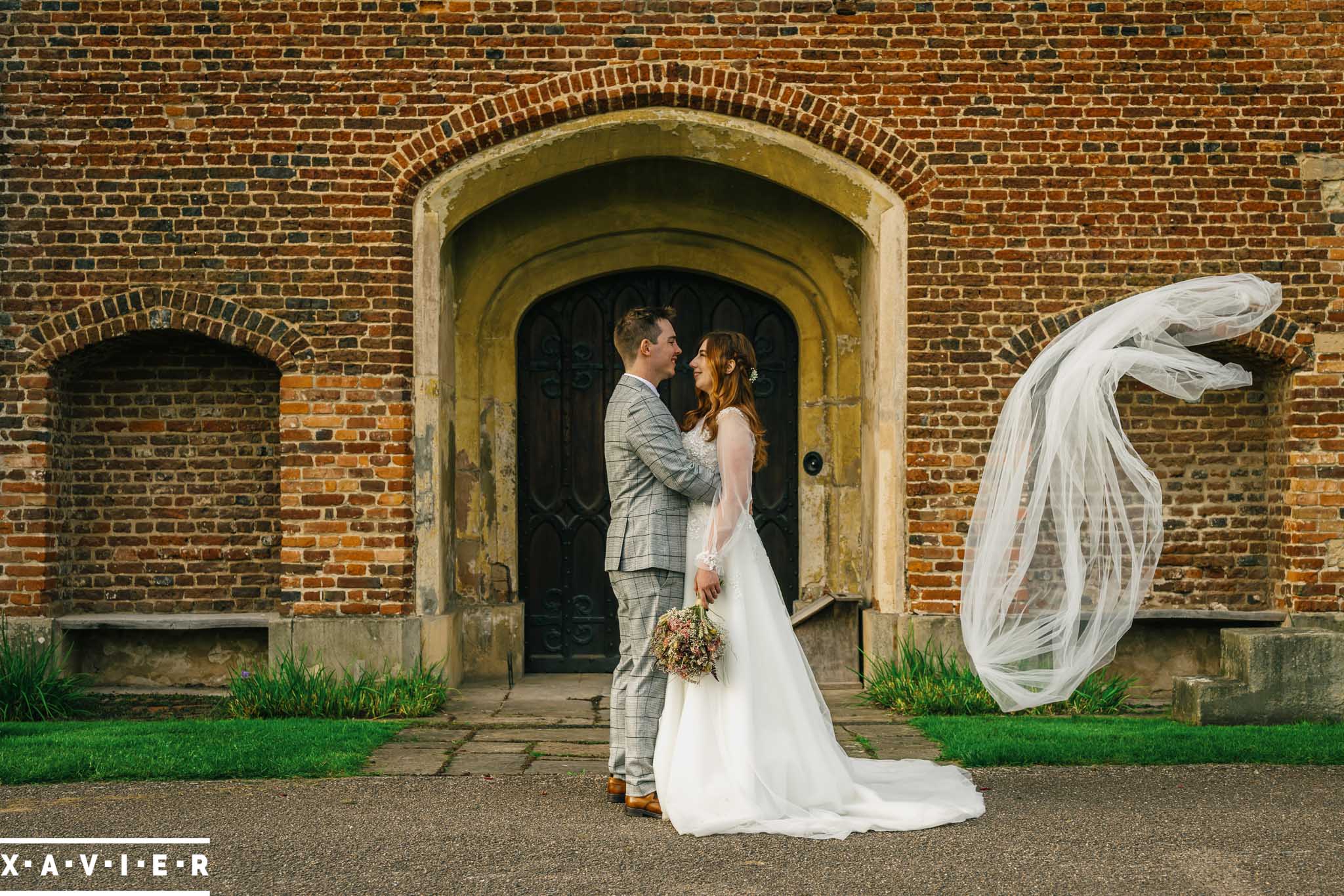Bride and groom hold embrace in the gardens