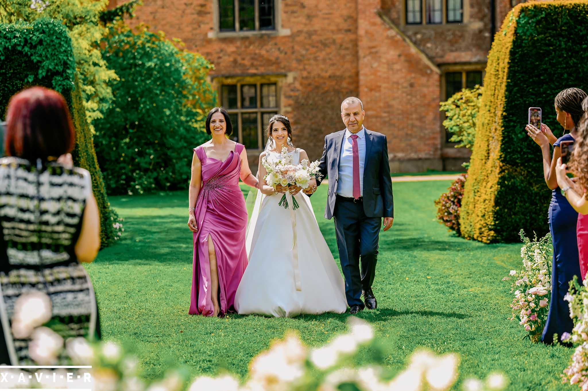 bride walks to the altar with her parents