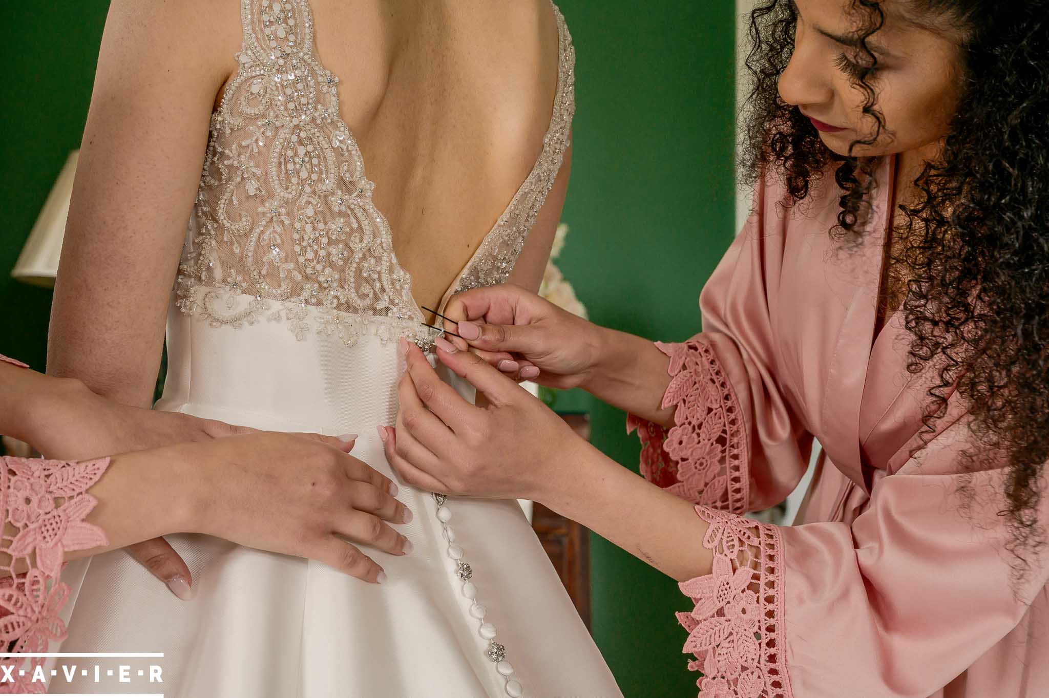 bride has her wedding dress fastened