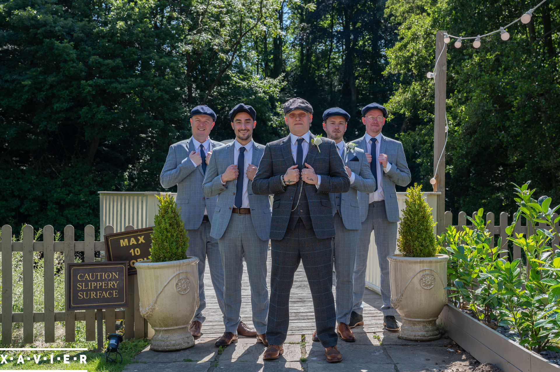 the groomsmen are posing in suits and flatcaps