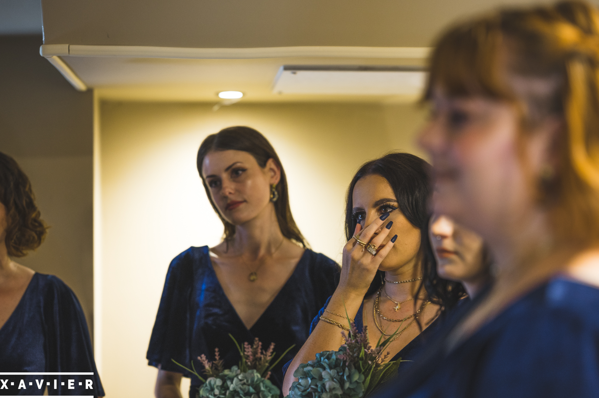 bridesmaids look on emotionally