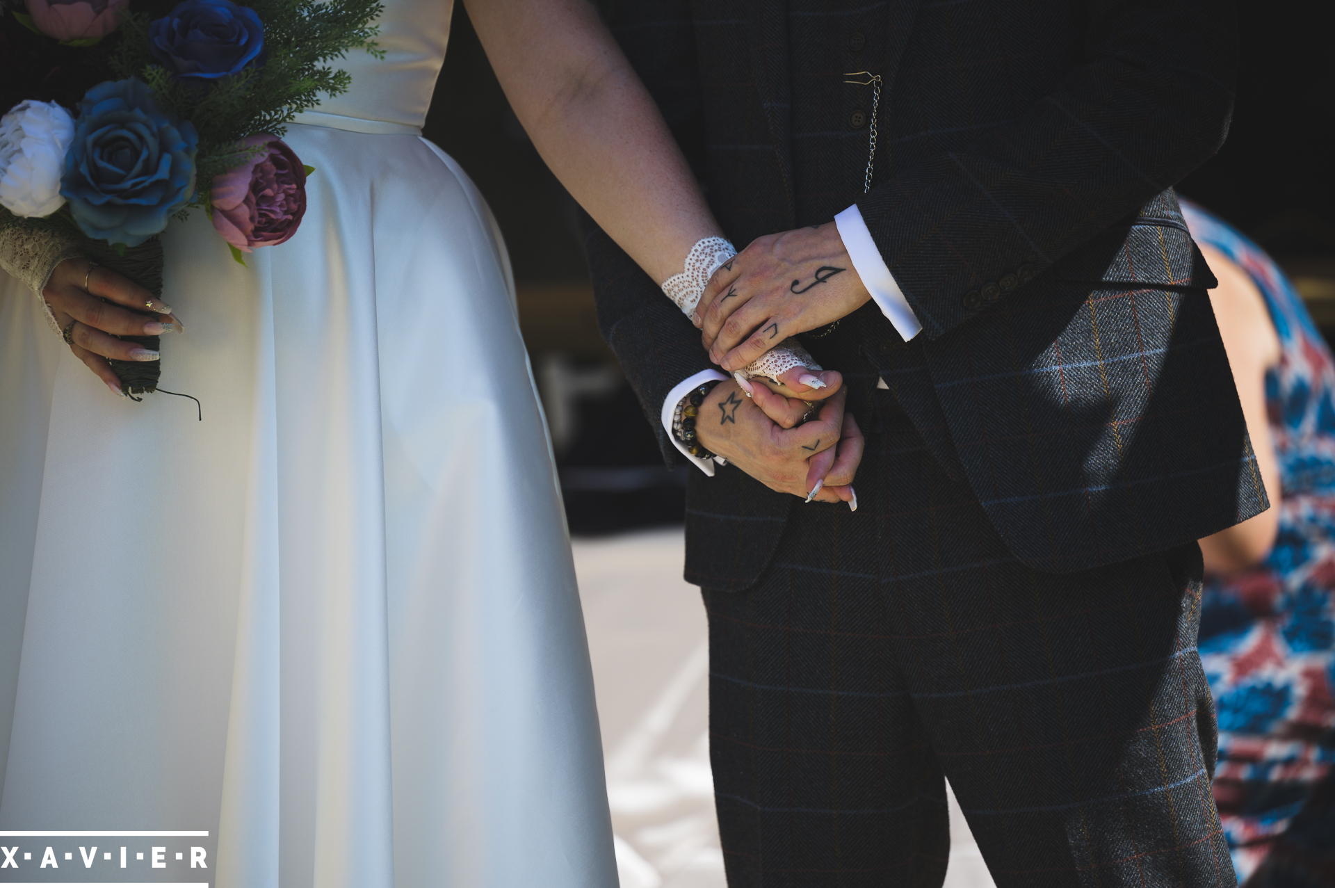 close up of bride and groom holding hands