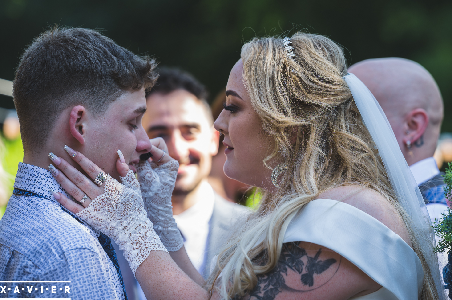 bride wipes a tear away from son