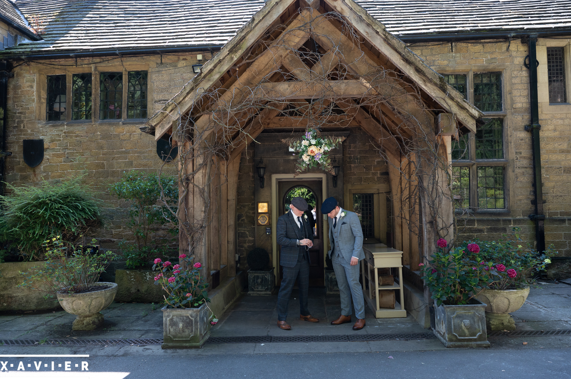the groom and bestman stand outside whitley hall 