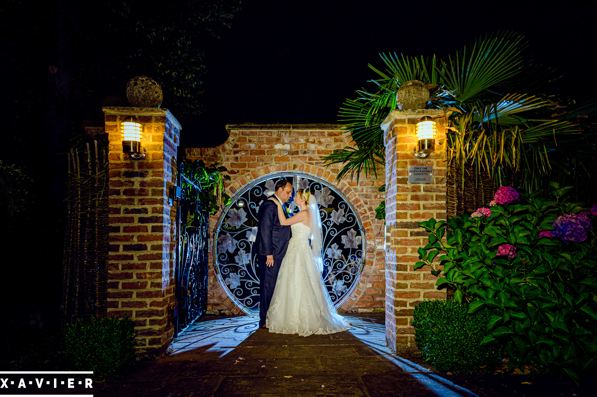 bride and groom stand outside the round gates