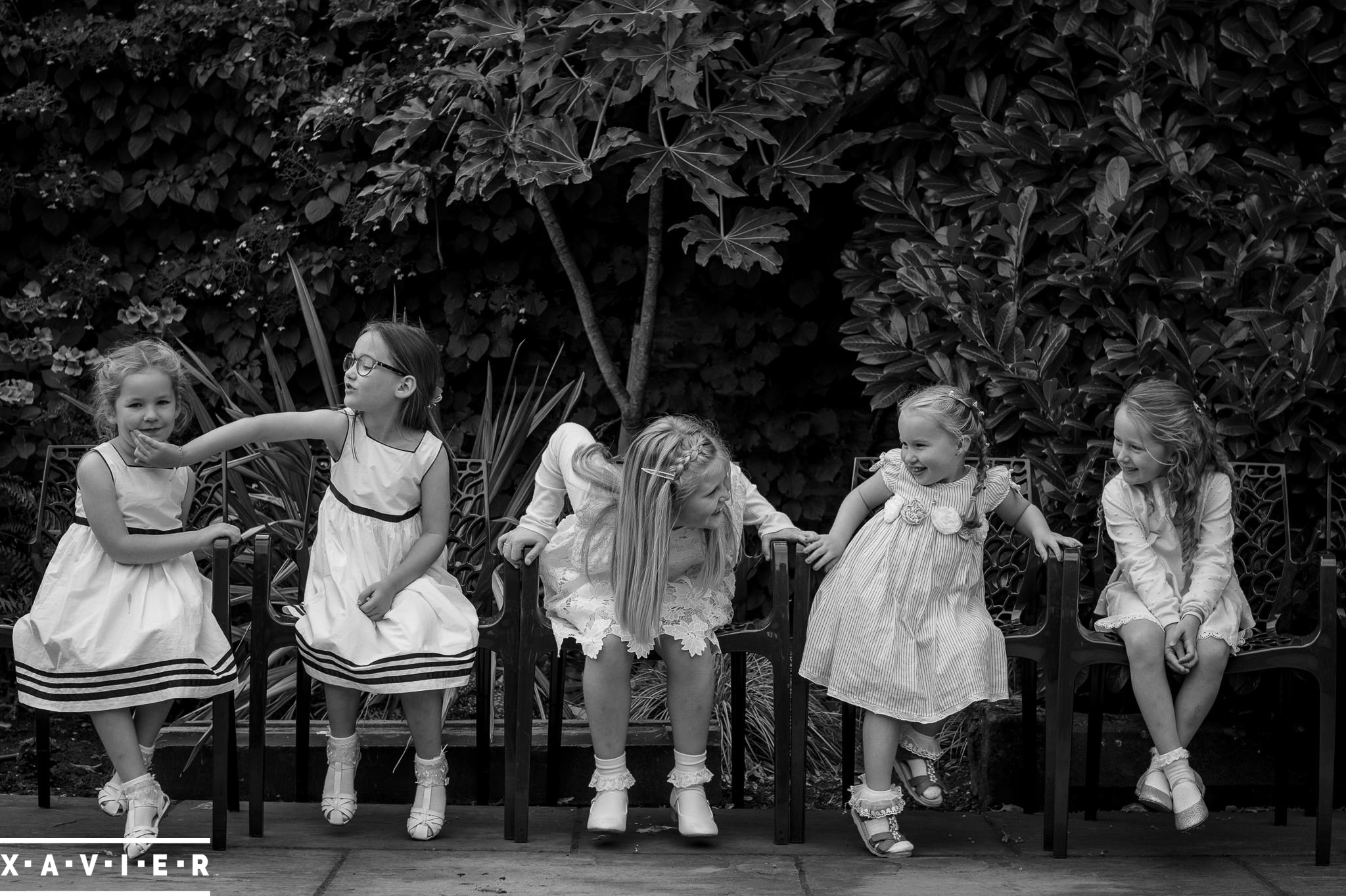 flower girls sit and chat on a bench