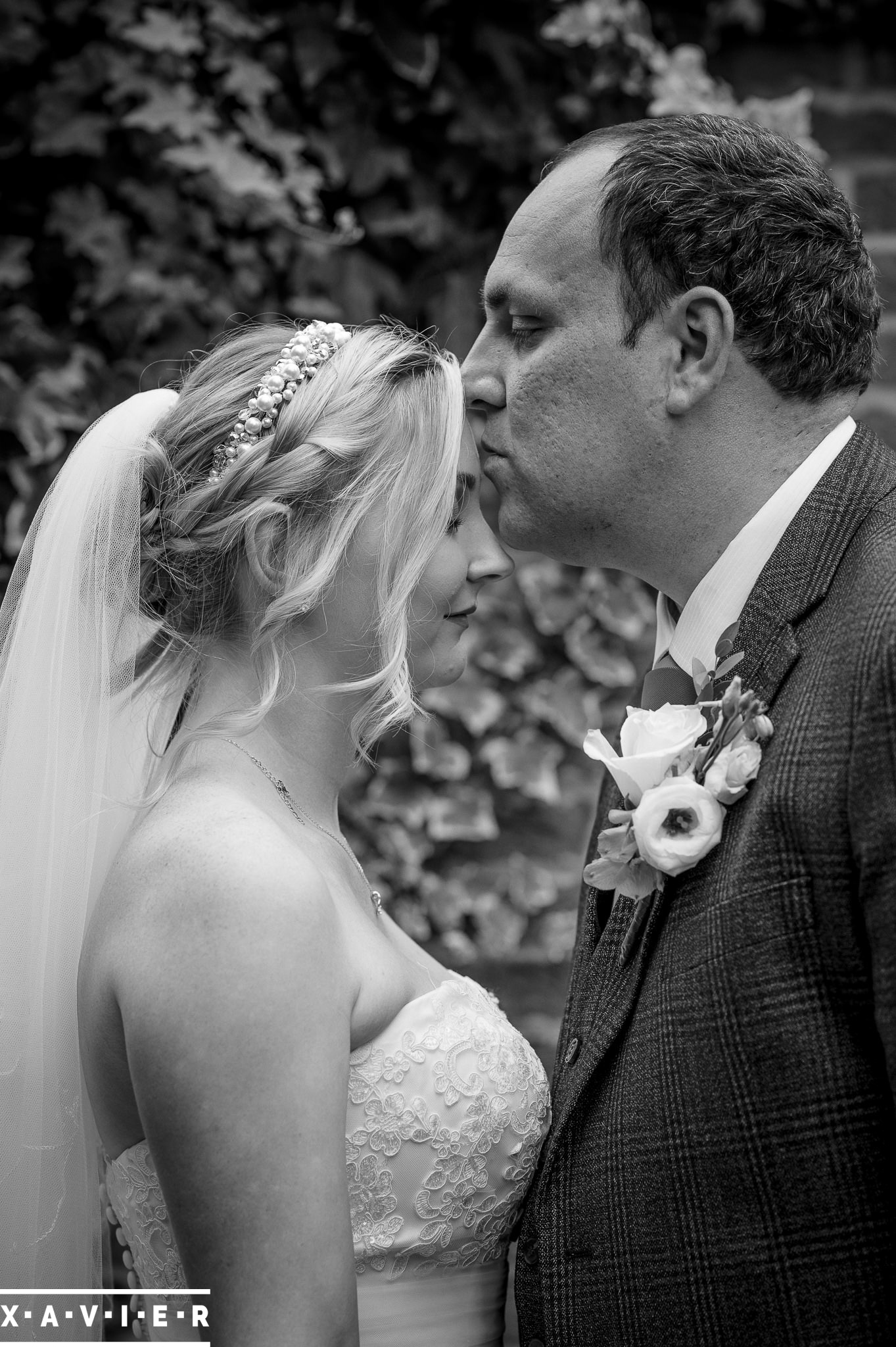 groom kisses the bride on the forehead