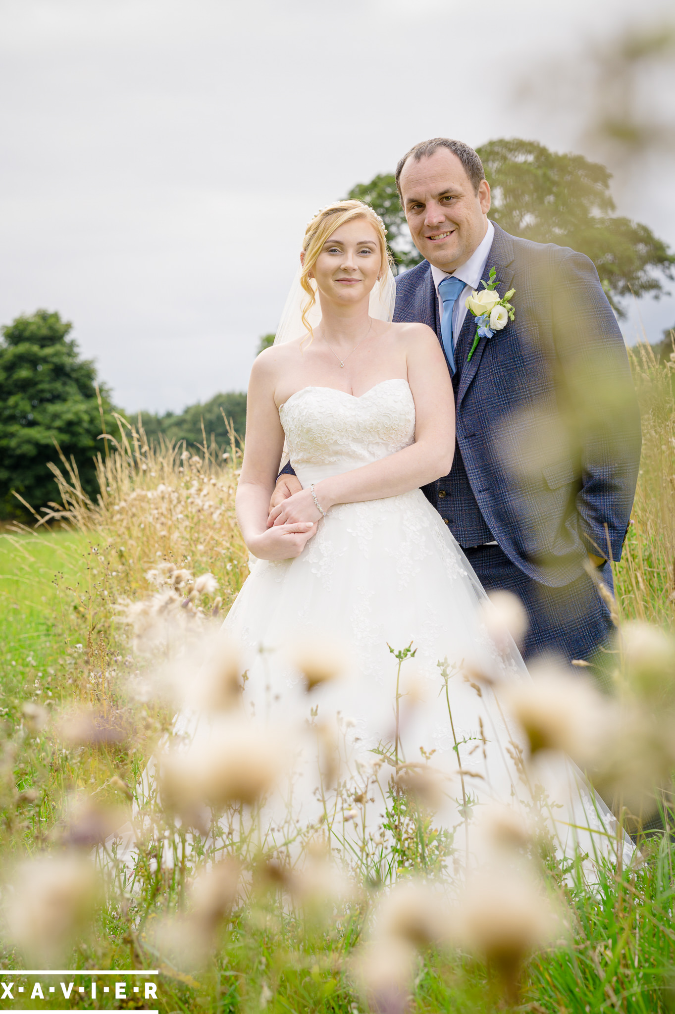 bride and groom stand in the flowers