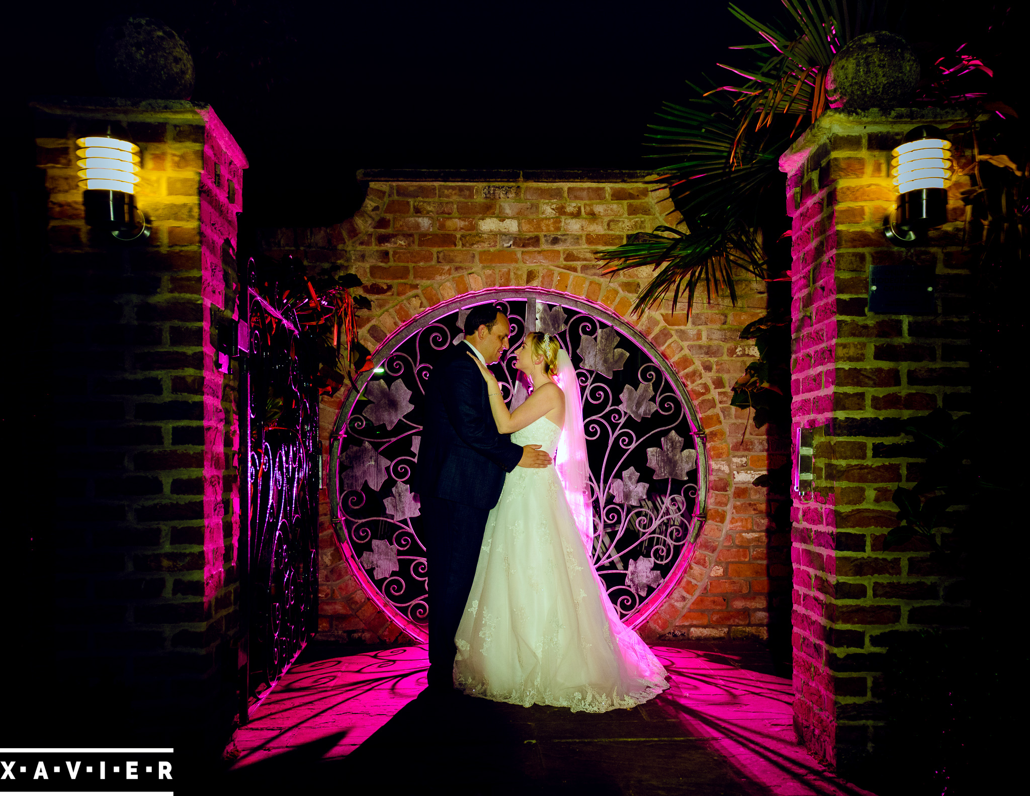bride and groom stand outside the round gate