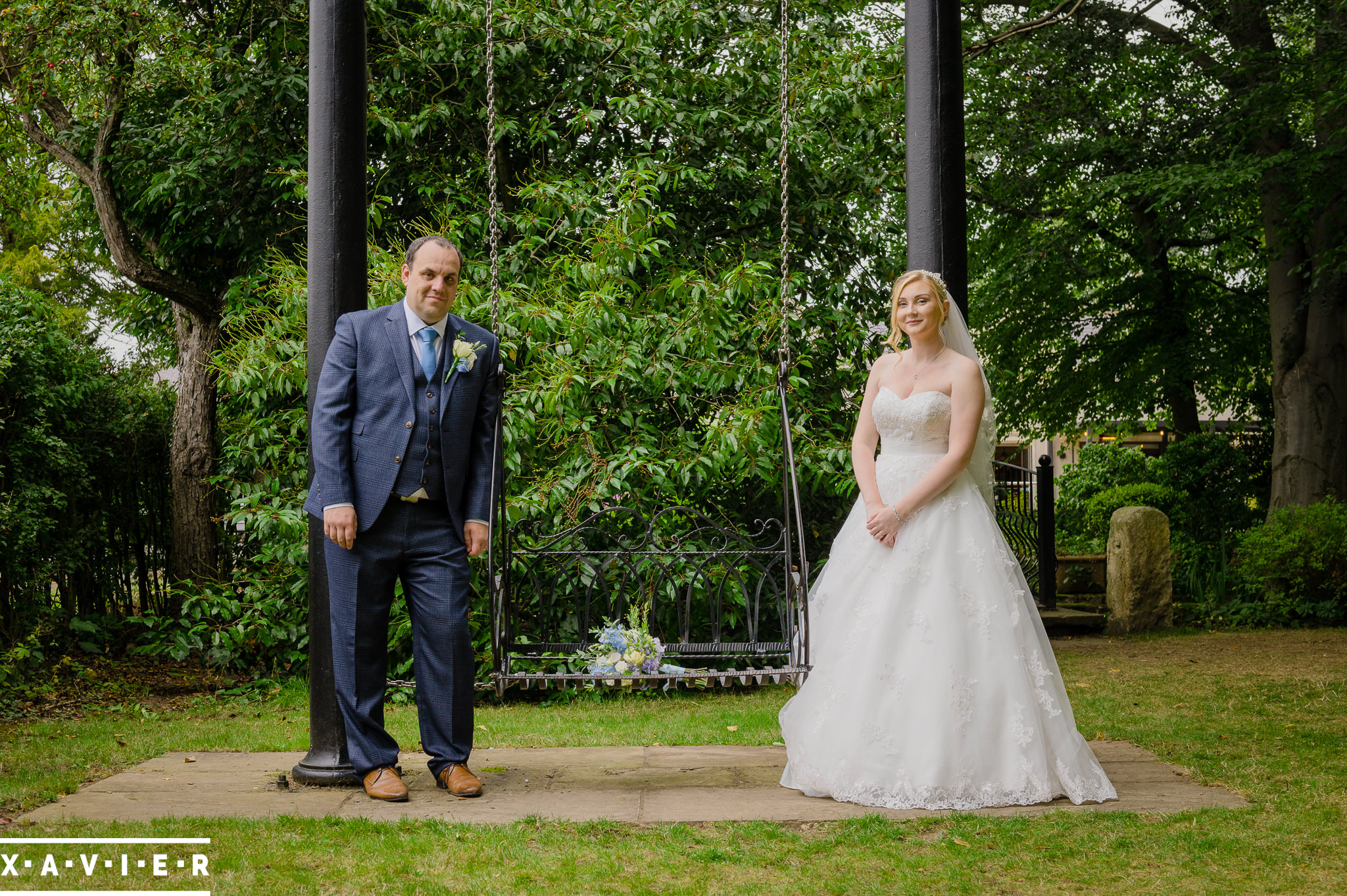 bride and groom stand by the swing