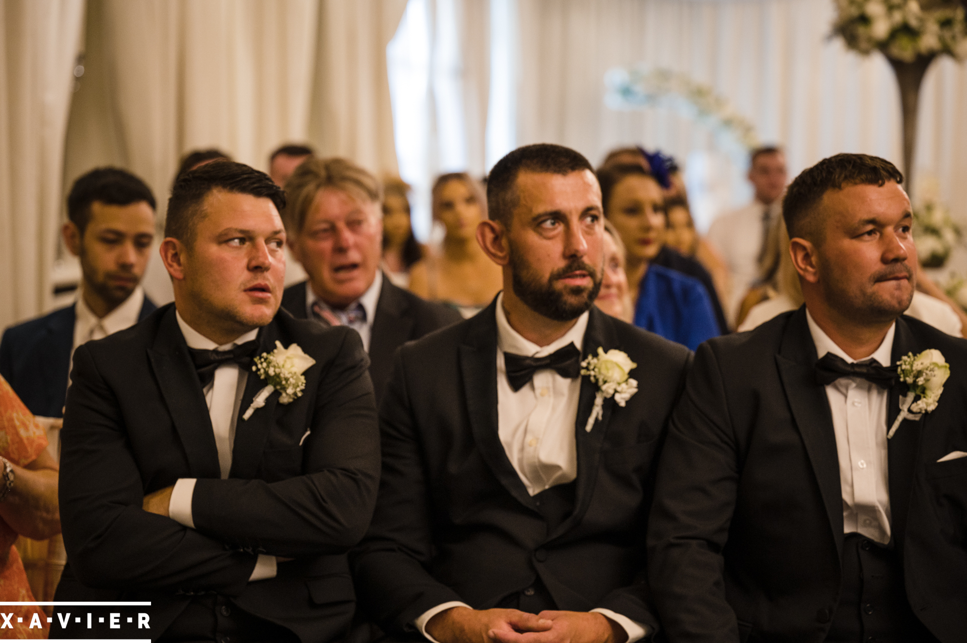 the groomsmen are sat together in the ceremony room