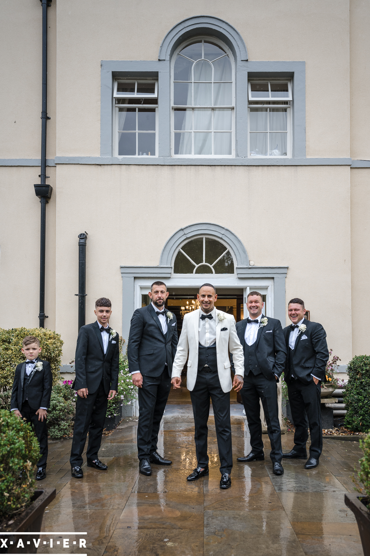 groomsmen are posing outside the hotel door
