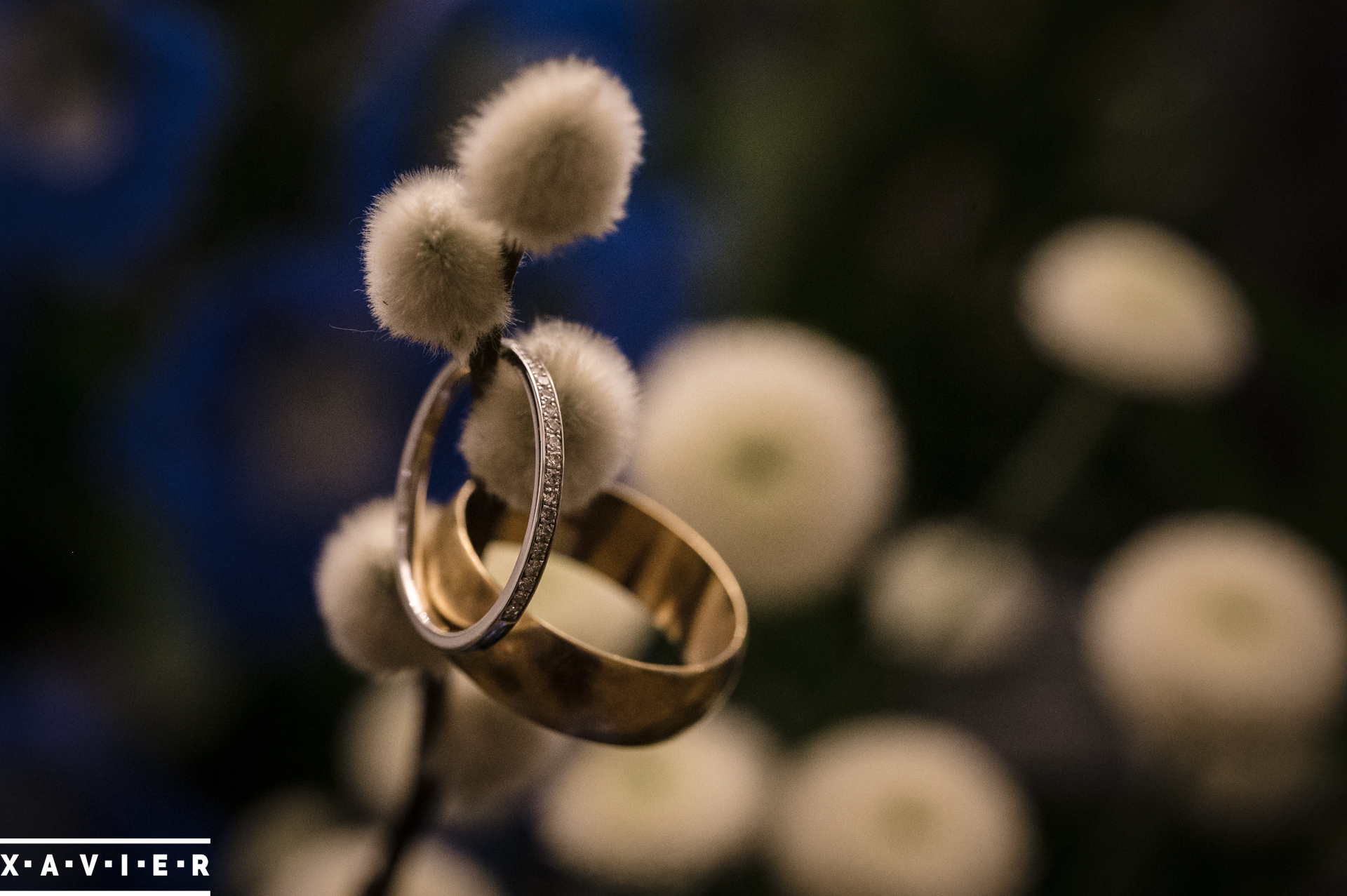 close up of wedding rings surrounded by flowers
