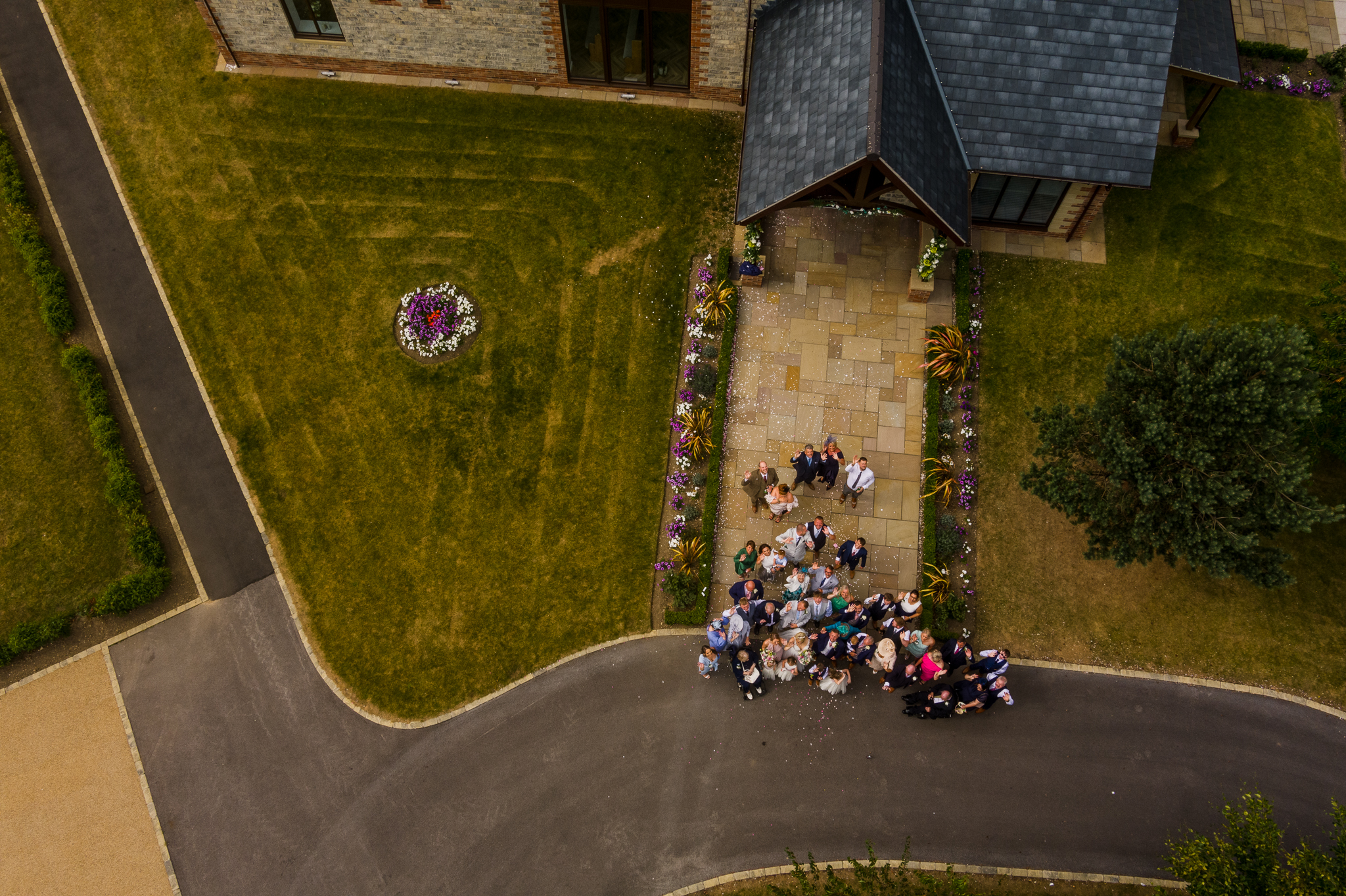 ariel view of guests throwing confetti on the bride and groom