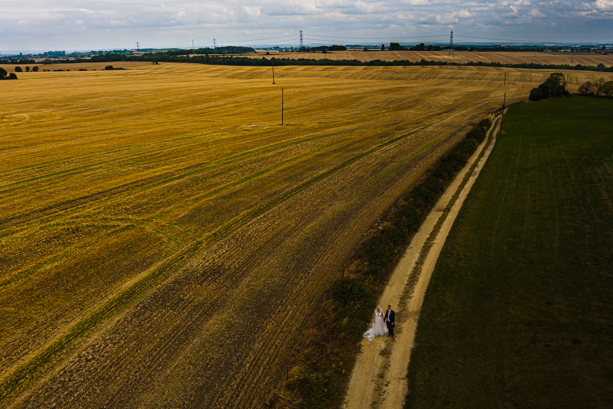 ariel view of bride and groom walking over fields