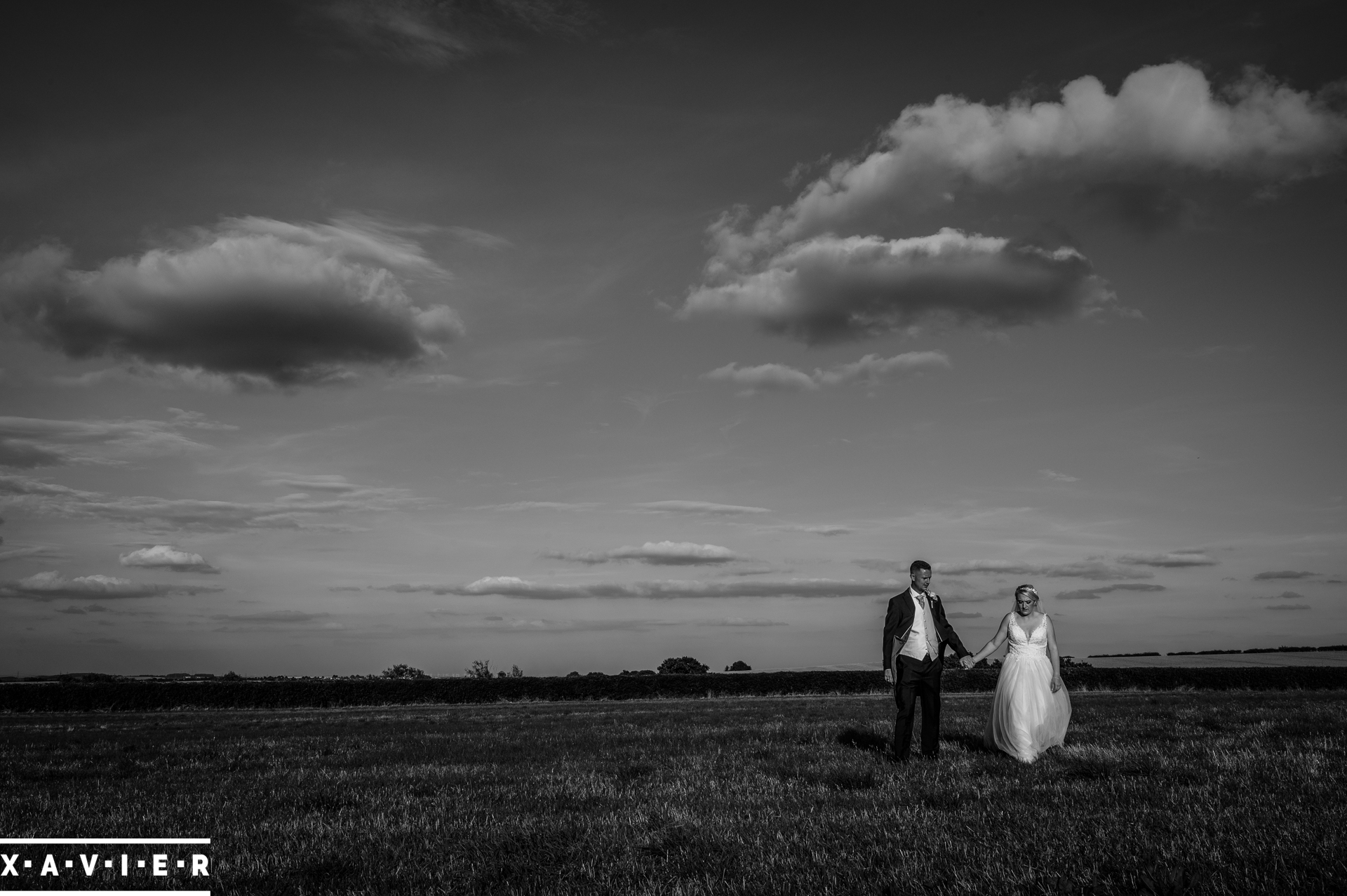 bride and groom walking over fields