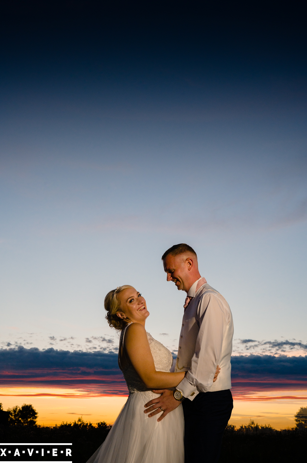 bride and groom smiling in the sunset