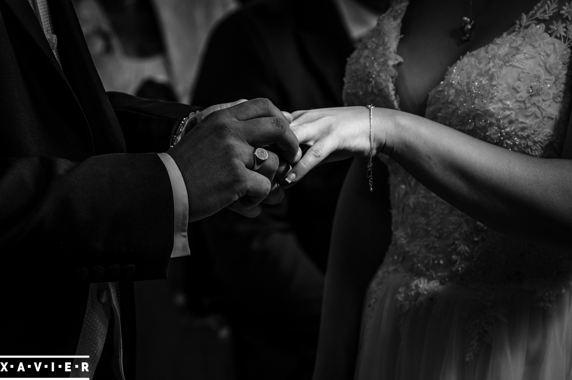 close up of groom putting the ring on the brides ring finger