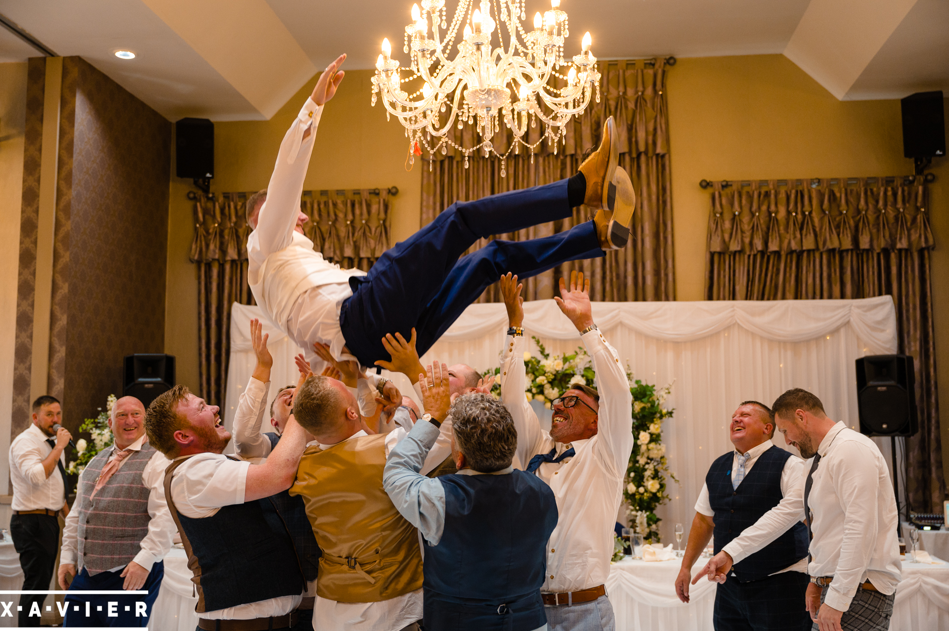 the groom is being thrown in the air by the guests