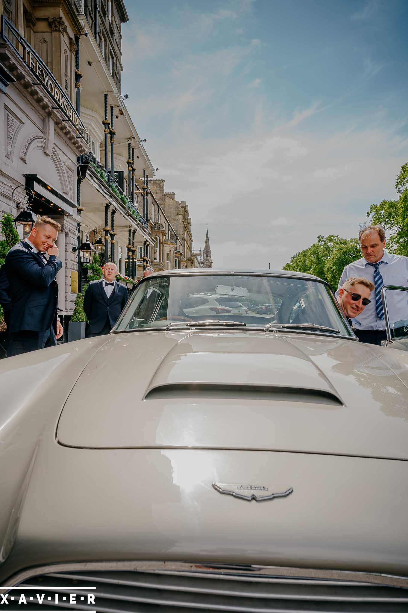 groom getting into surprise aston martin db5 wedding car