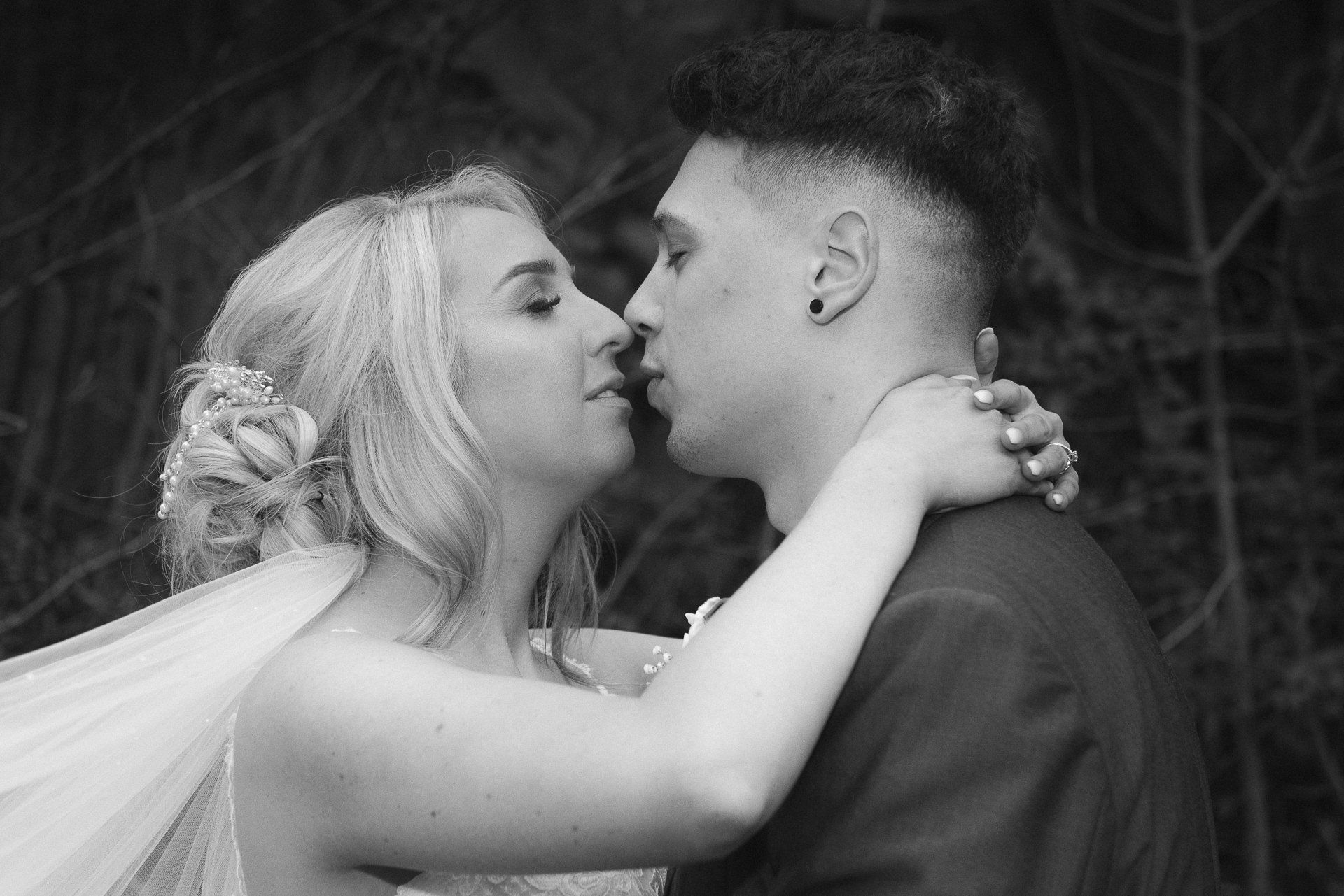 black and white photo of the bride and groom about to kiss
