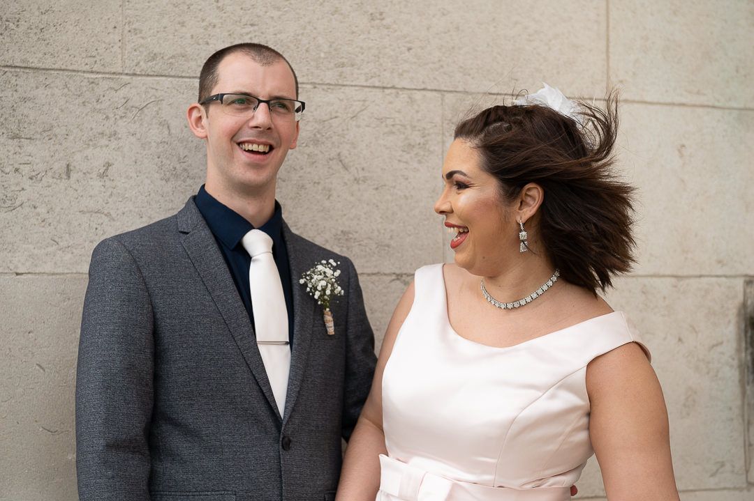 the bride and groom laugh about the wind