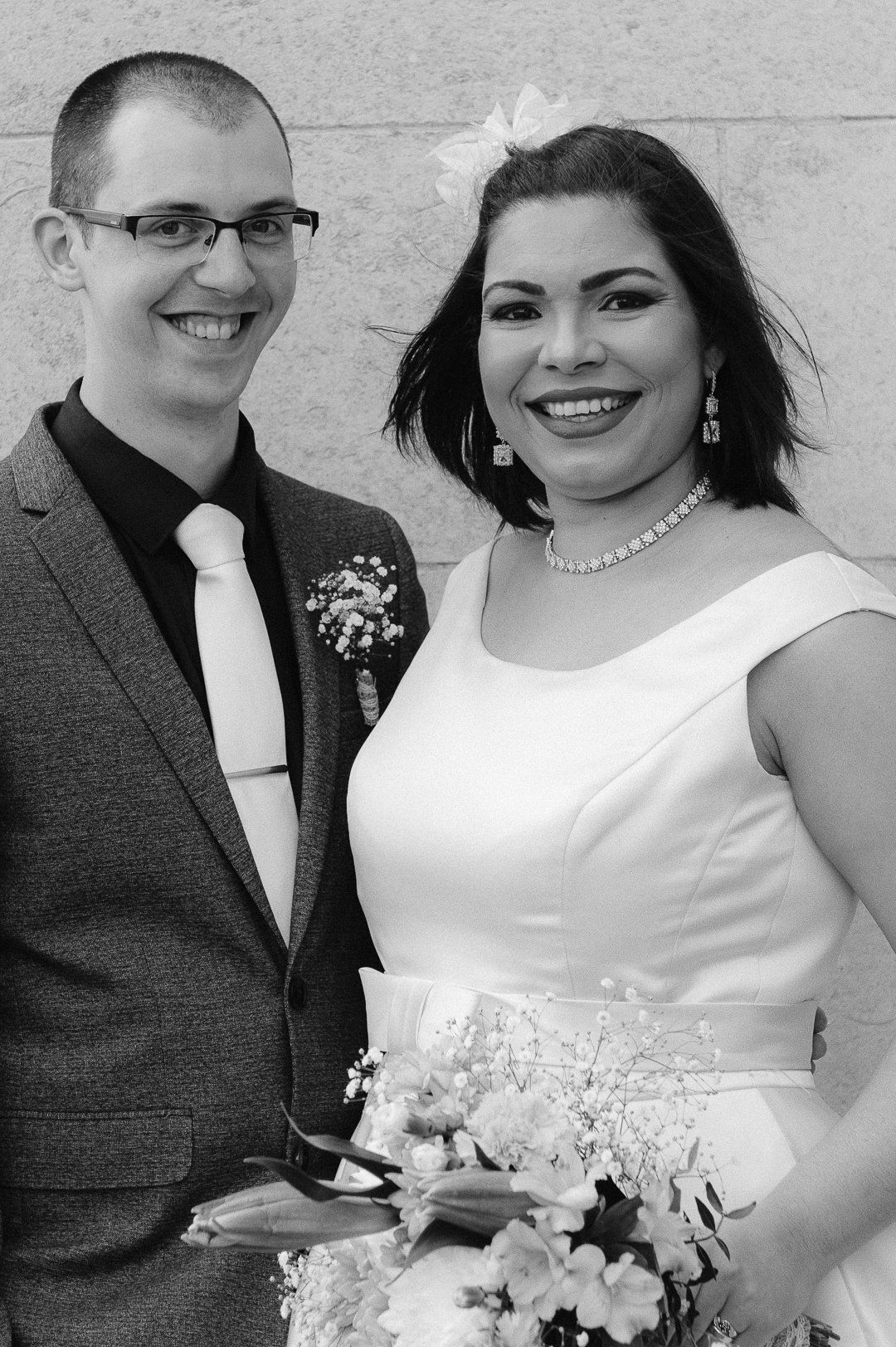 black and white image of the bride and groom smiling at the camera