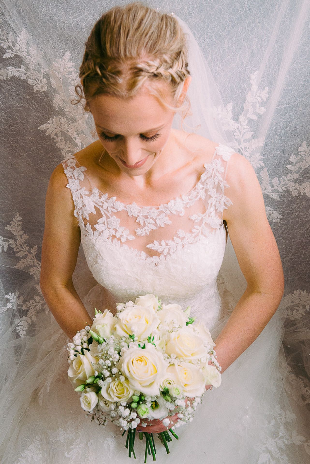 bride is kneeling and looking at her flowers