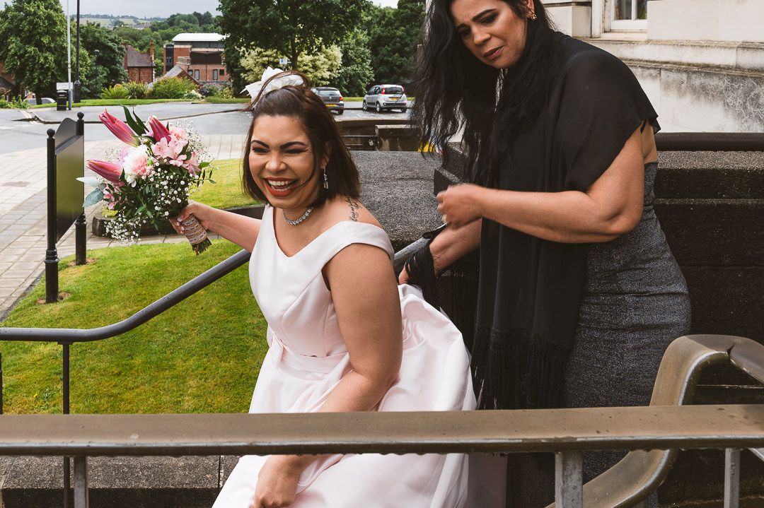 the bride is getting help to walk down the steps