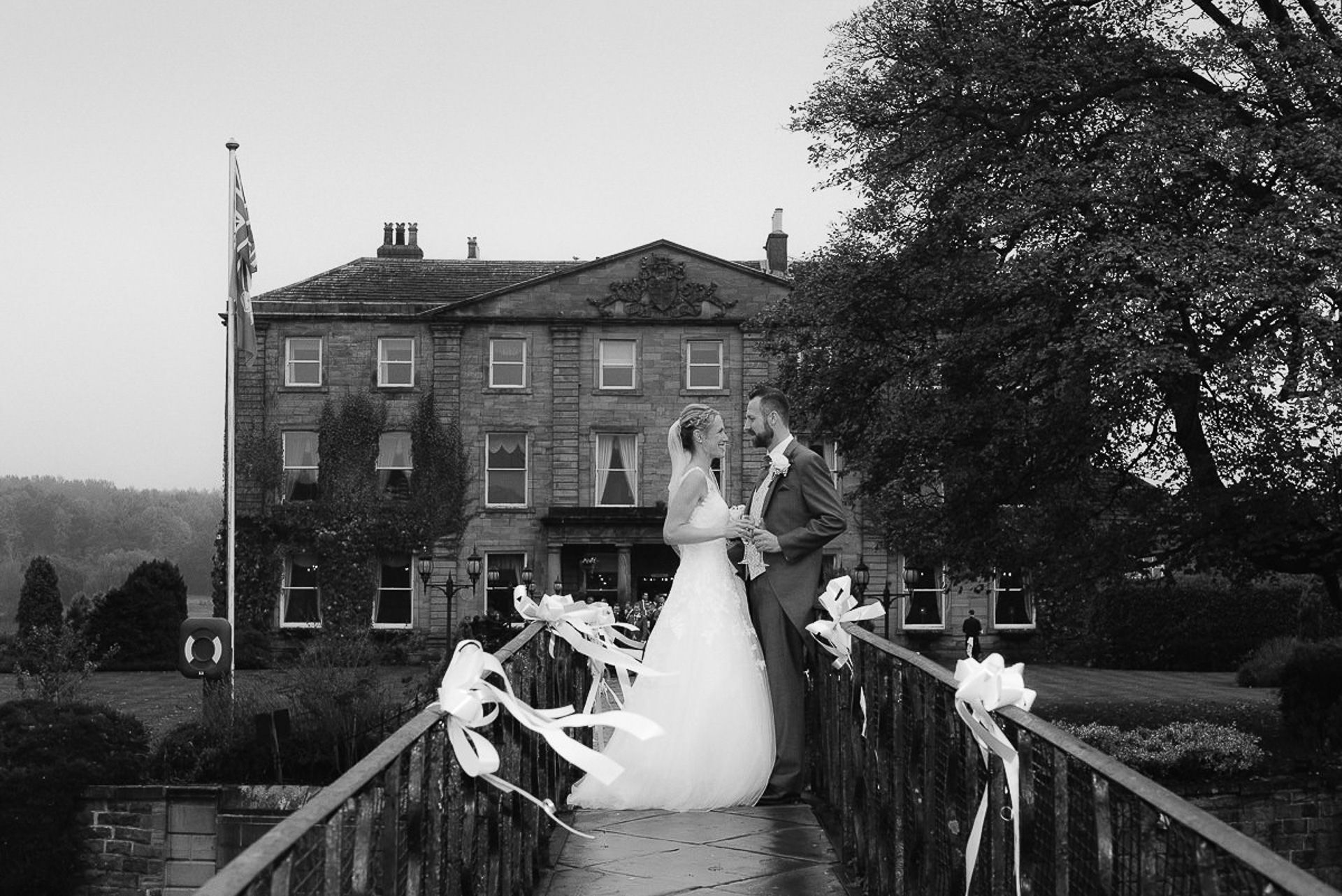 bride and groom stand face to face on the bridge