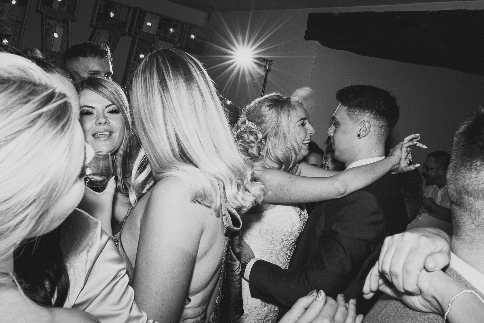 bride and groom on the dance floor with guests 