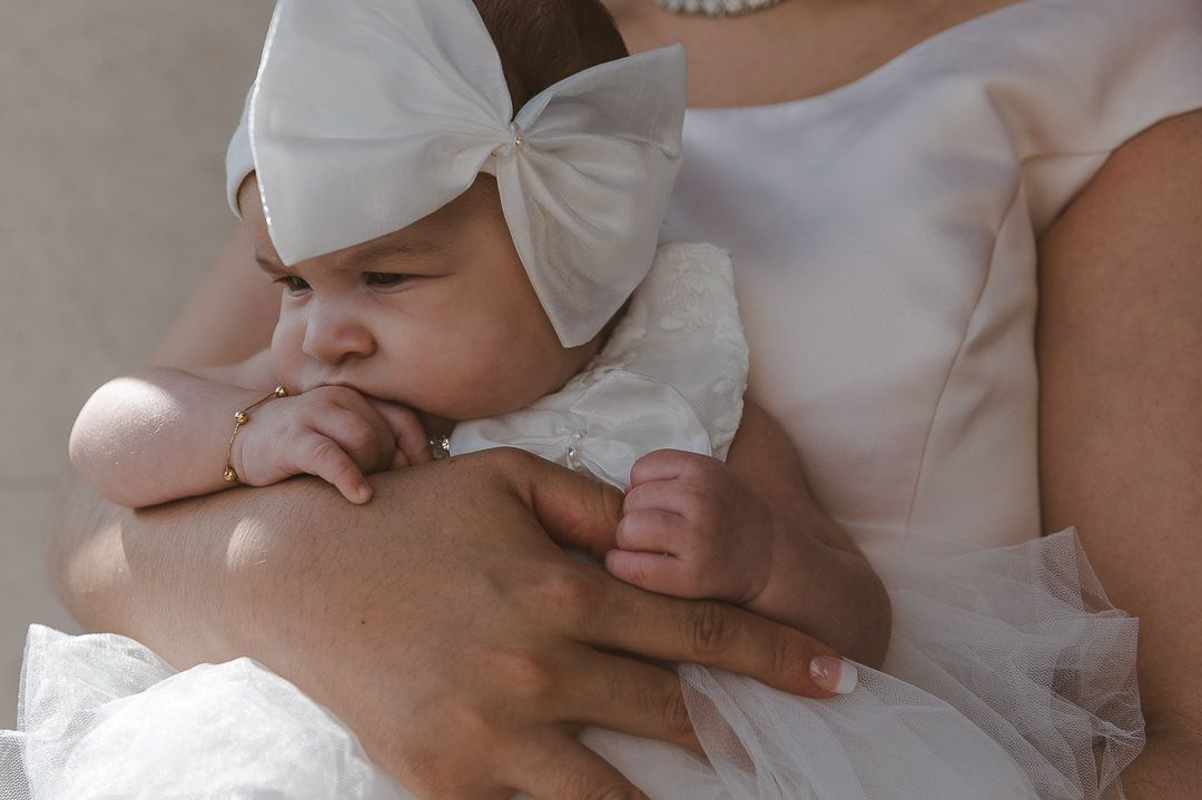 close up of the brides baby with a large bow on her head