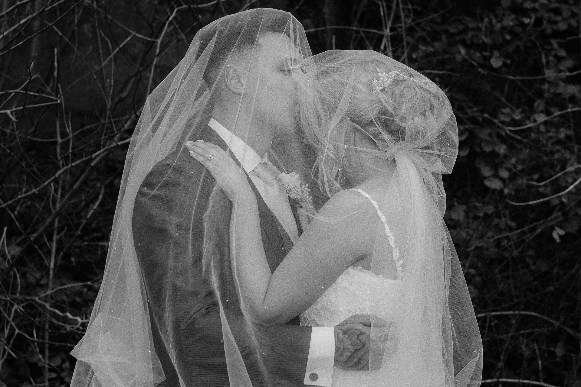 groom kisses the bride on her forehead under her veil