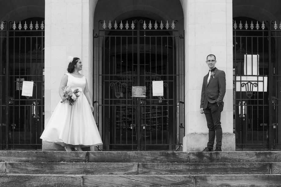 The bride and groom stand socially distanced apart