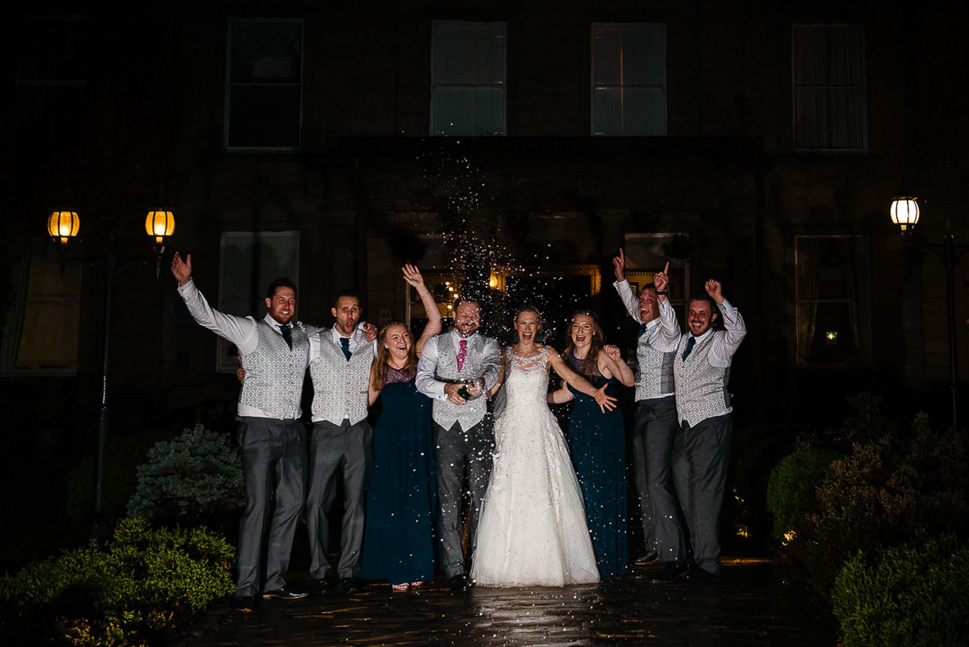 bride and groom celebrate with champagne outside walton hall