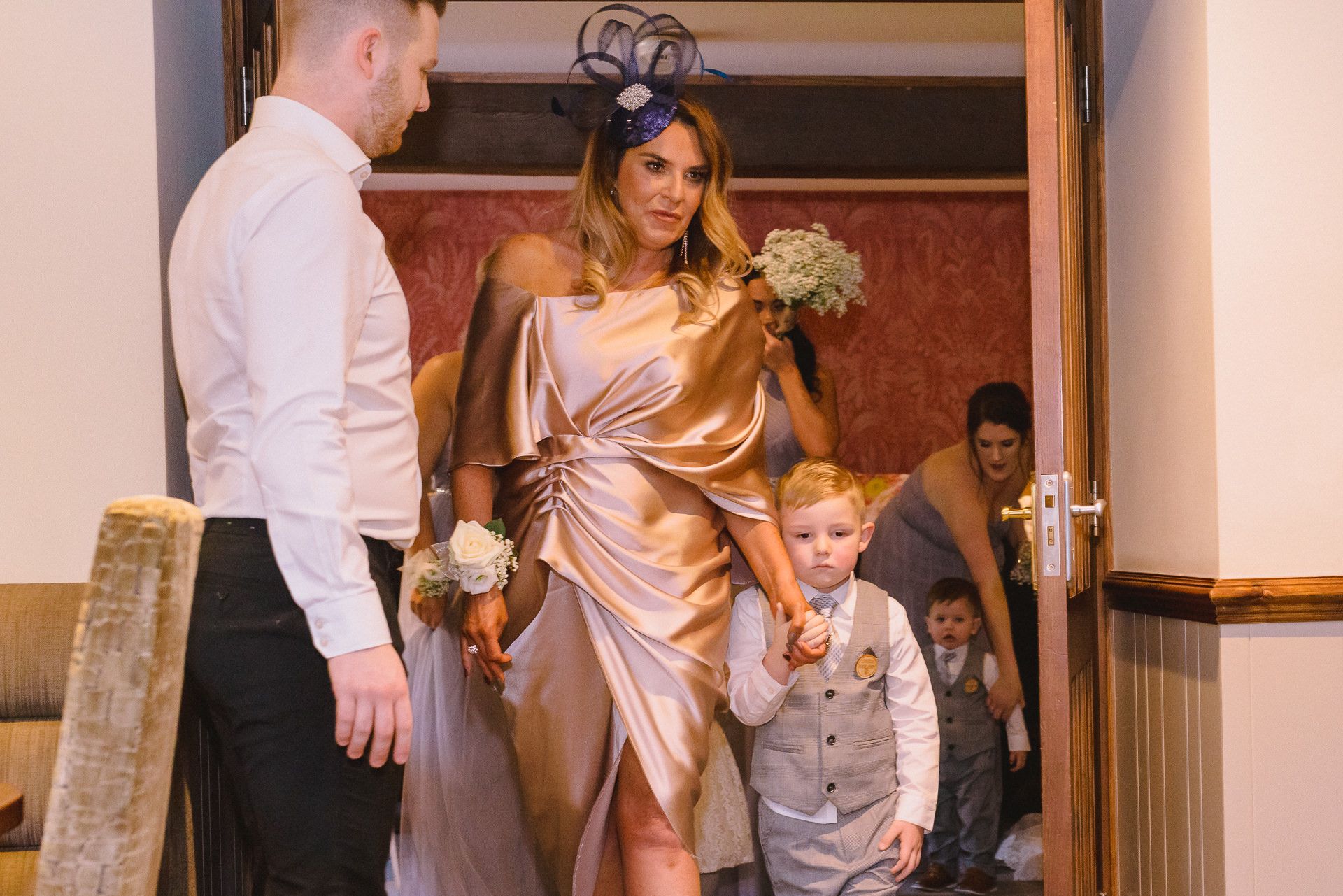 pageboy walks down the aisle with a bridesmaid