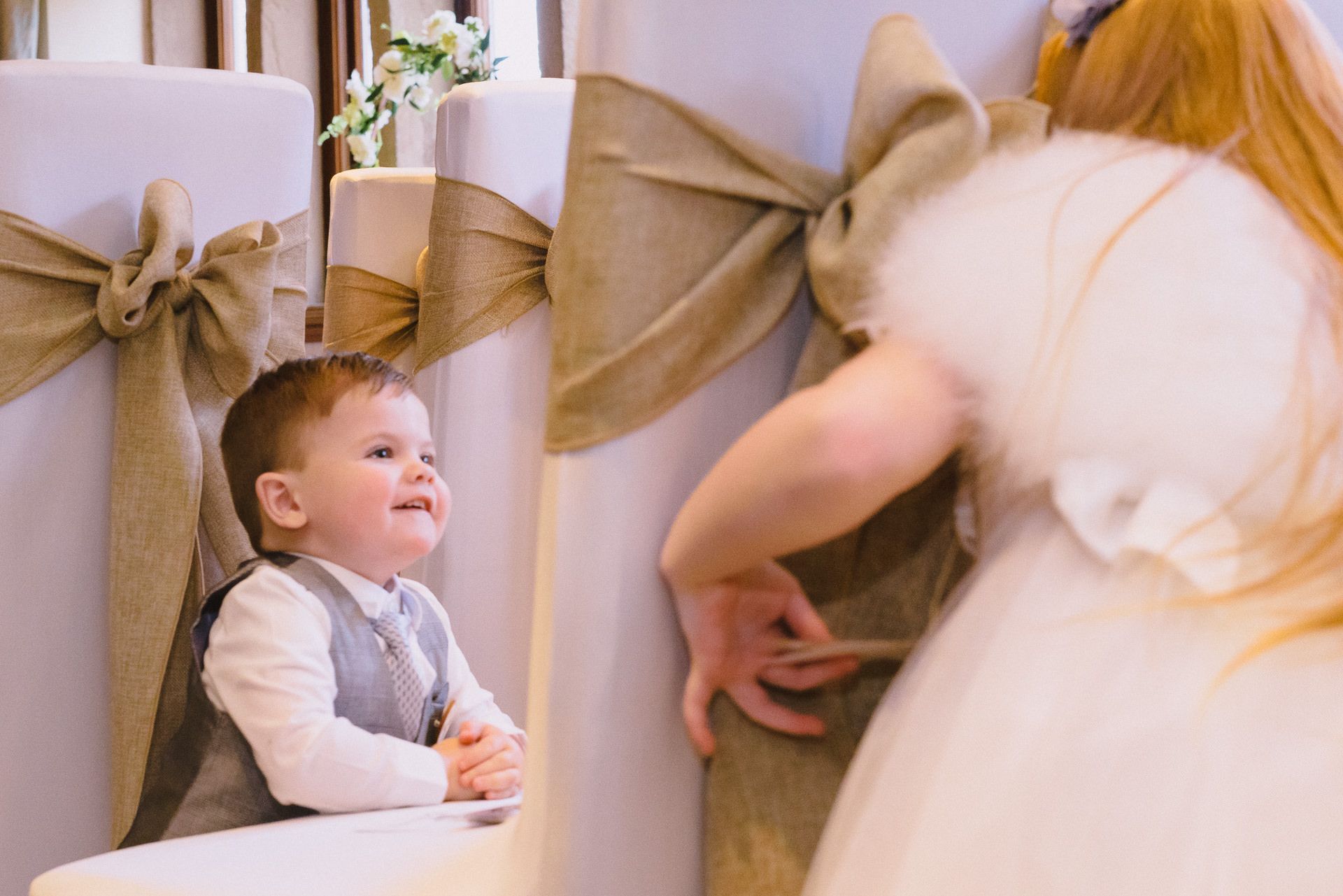 pageboy plays with his sister in the ceremony room